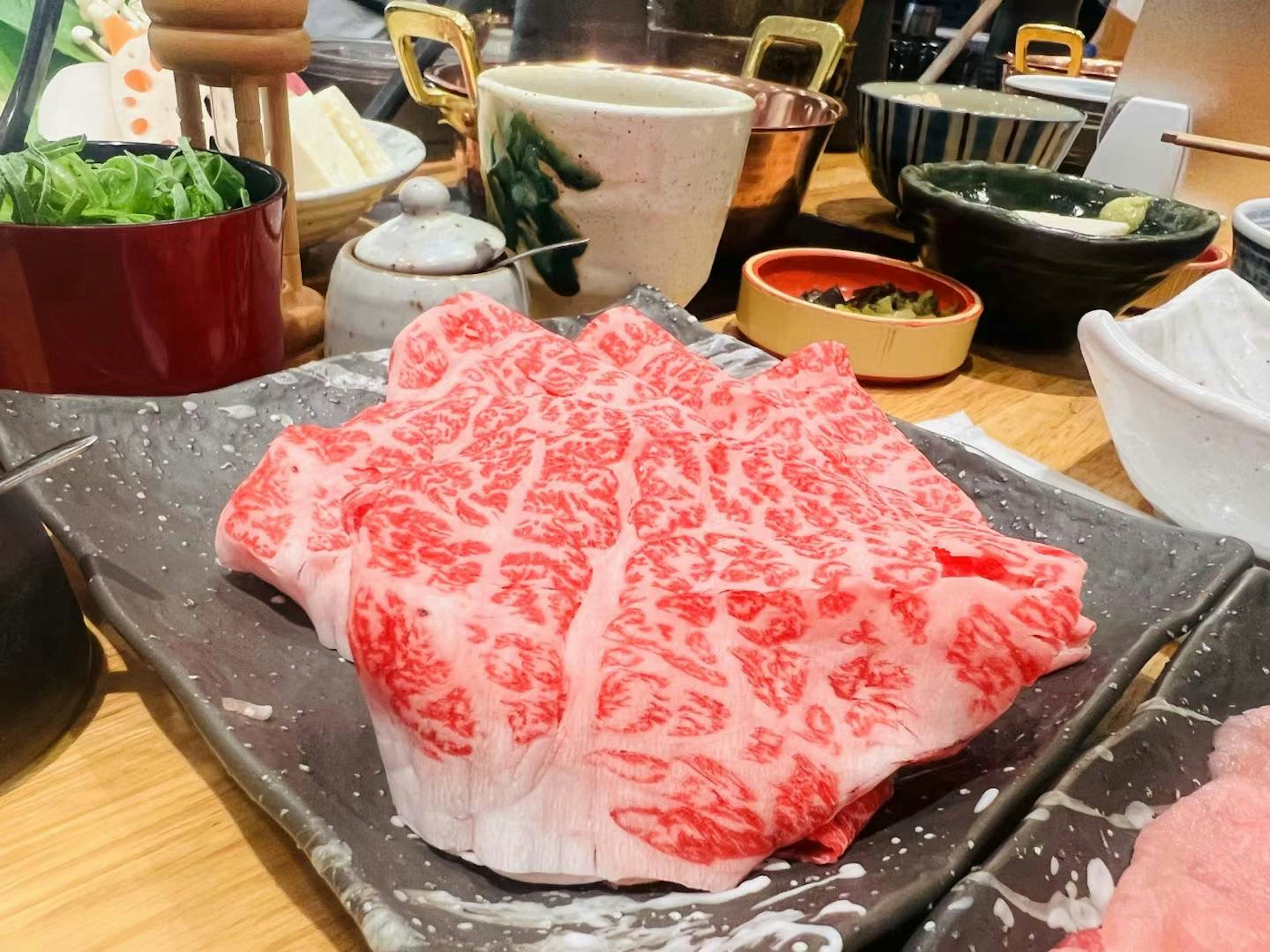 Hermosa rebanada marmoleada de carne Wagyu en un plato negro