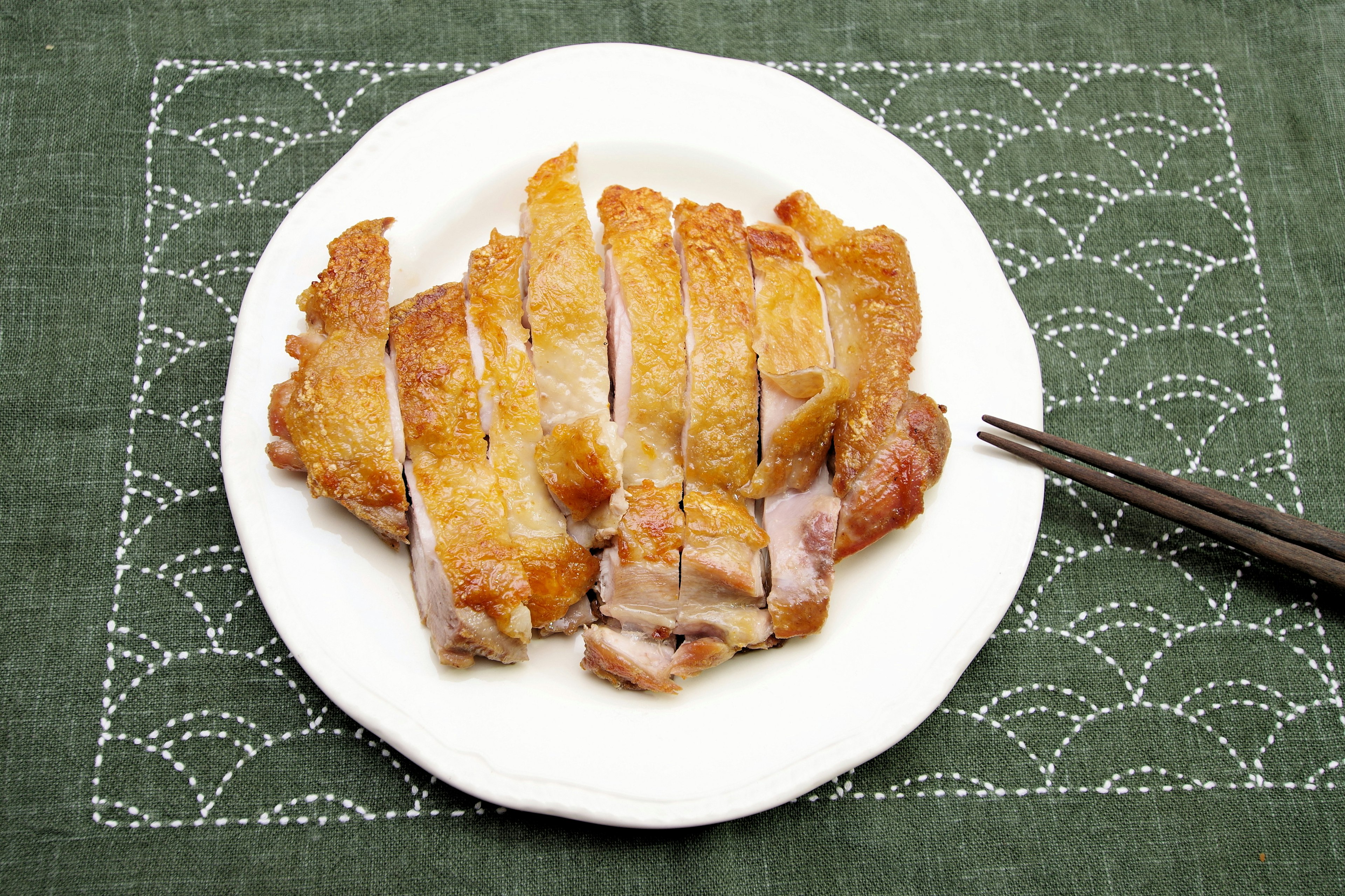 Sliced roasted chicken served on a white plate