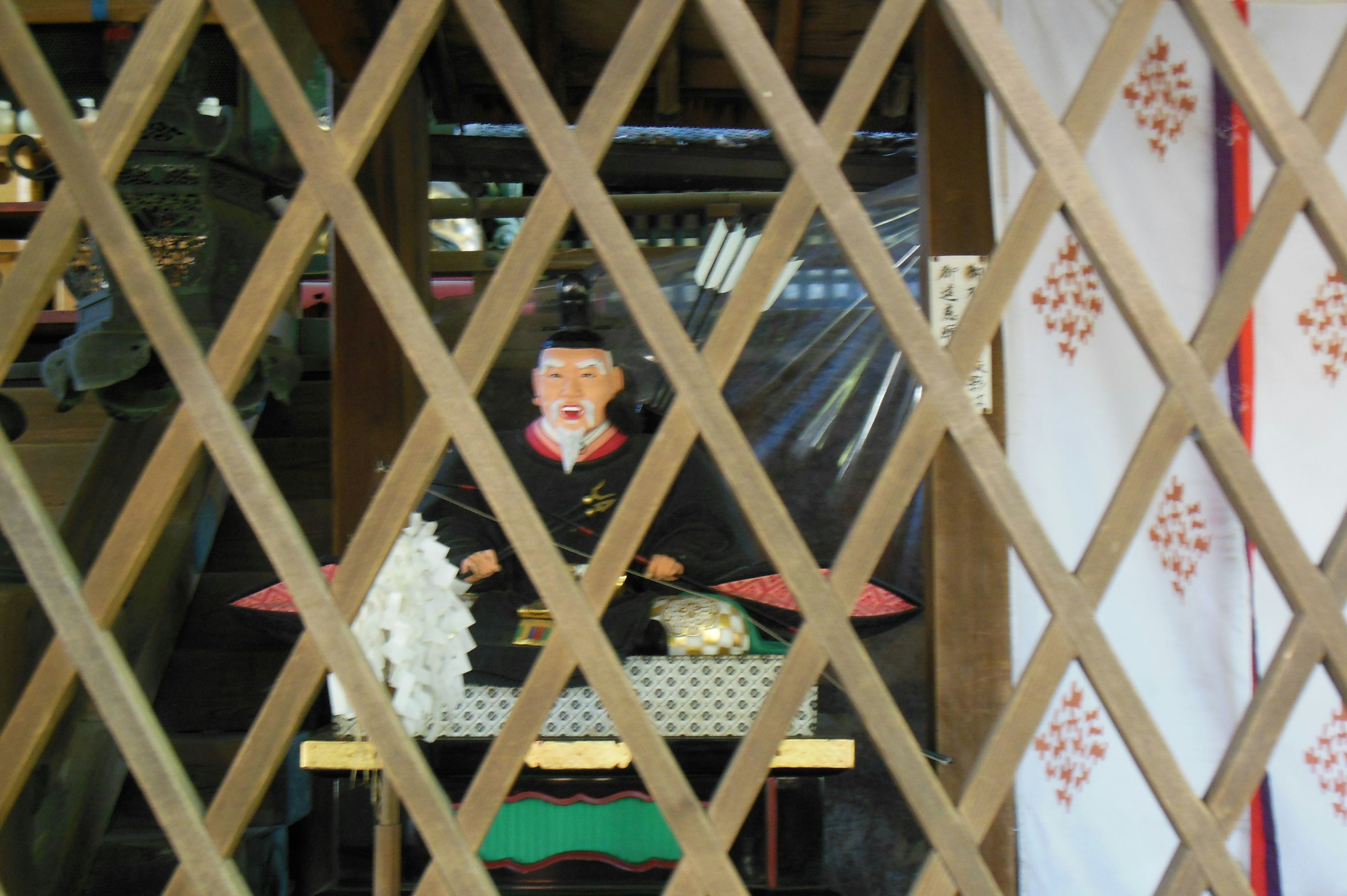 Vue d'un autel de sanctuaire et d'une figure à travers une treillis en bois