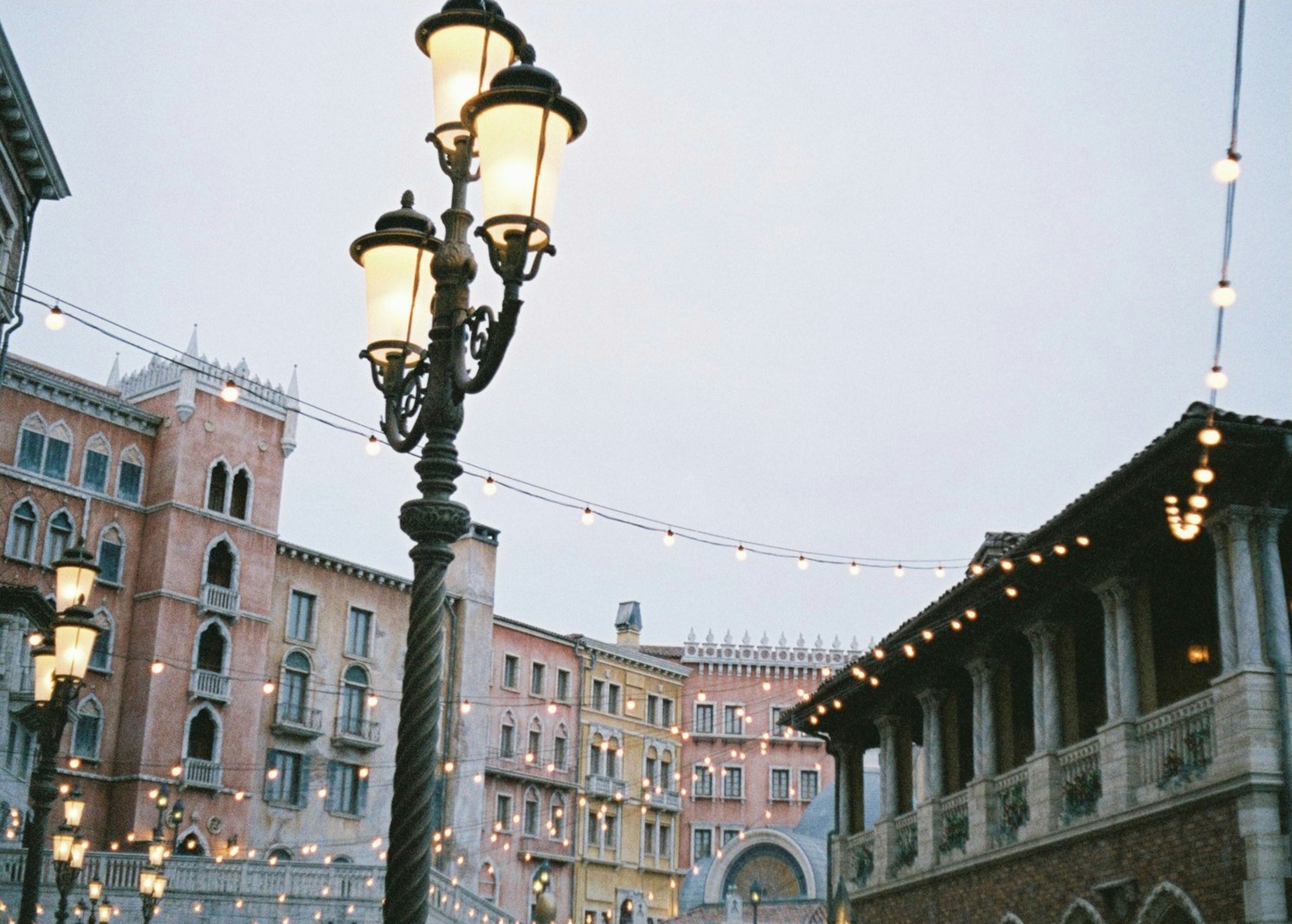 Vista di strada affascinante con edifici eleganti e lampioni vintage illuminati da luci soffuse