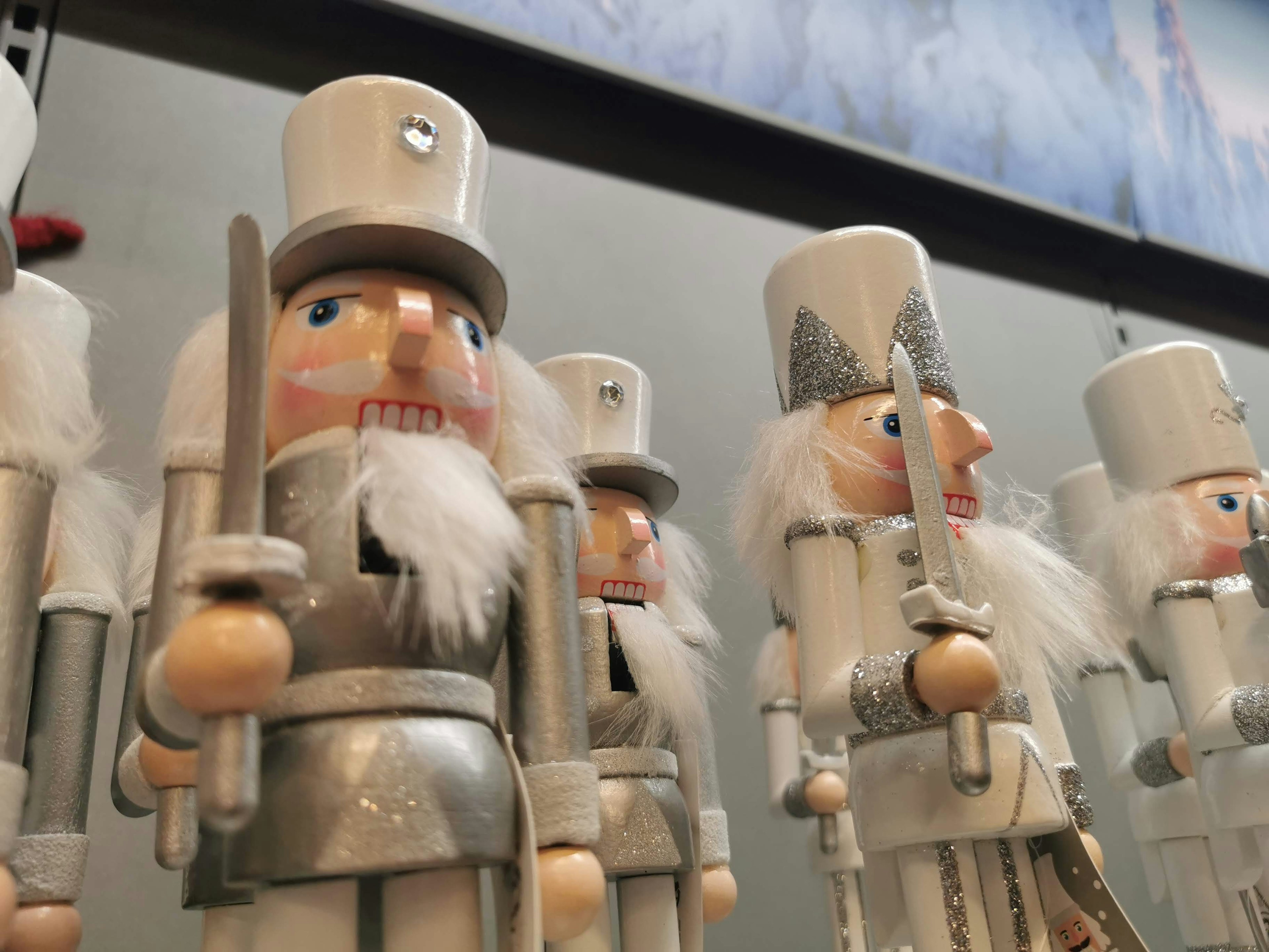 Wooden nutcracker soldiers in white and silver decorations lined up