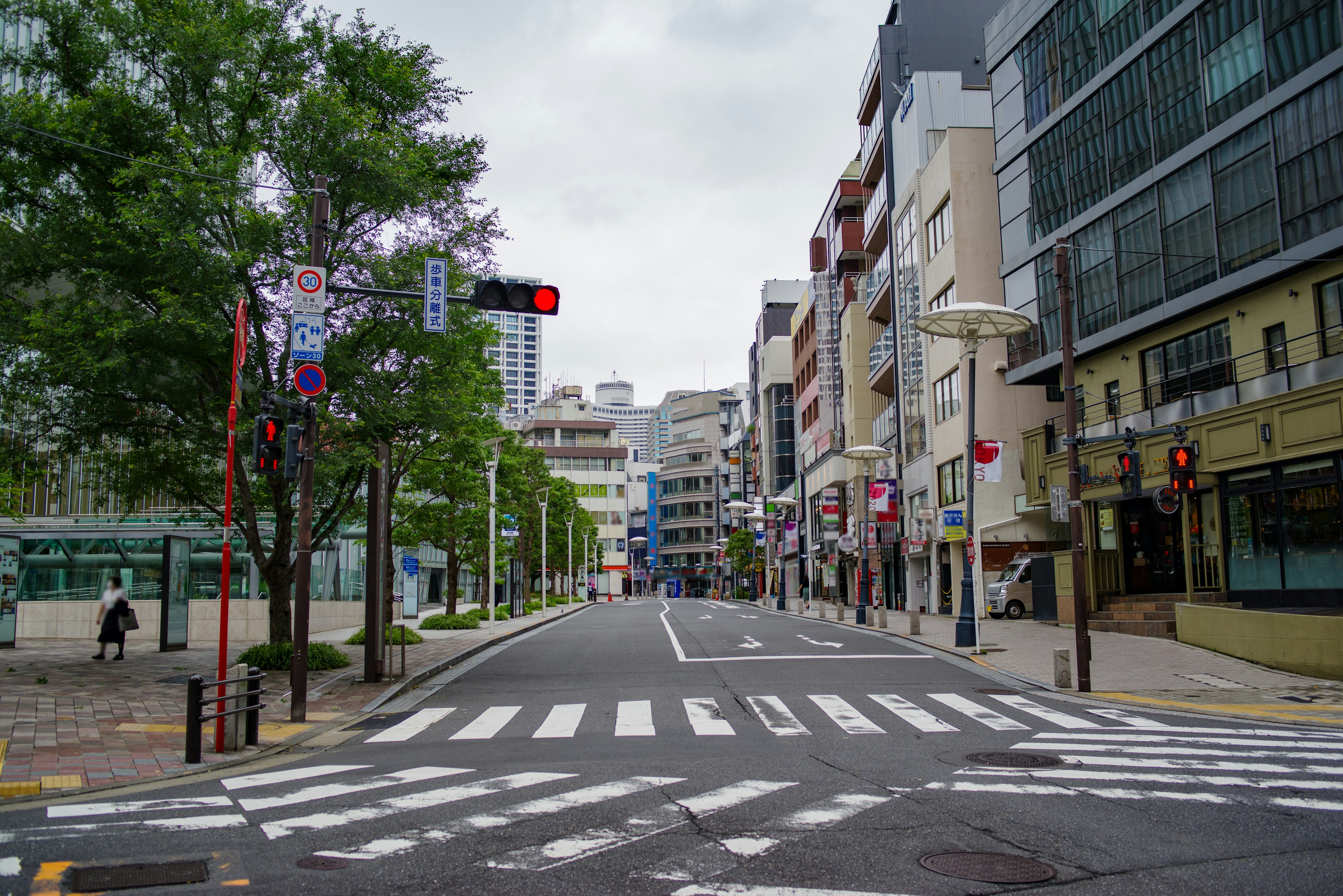 Calle tranquila de la ciudad con semáforo rojo y paso peatonal