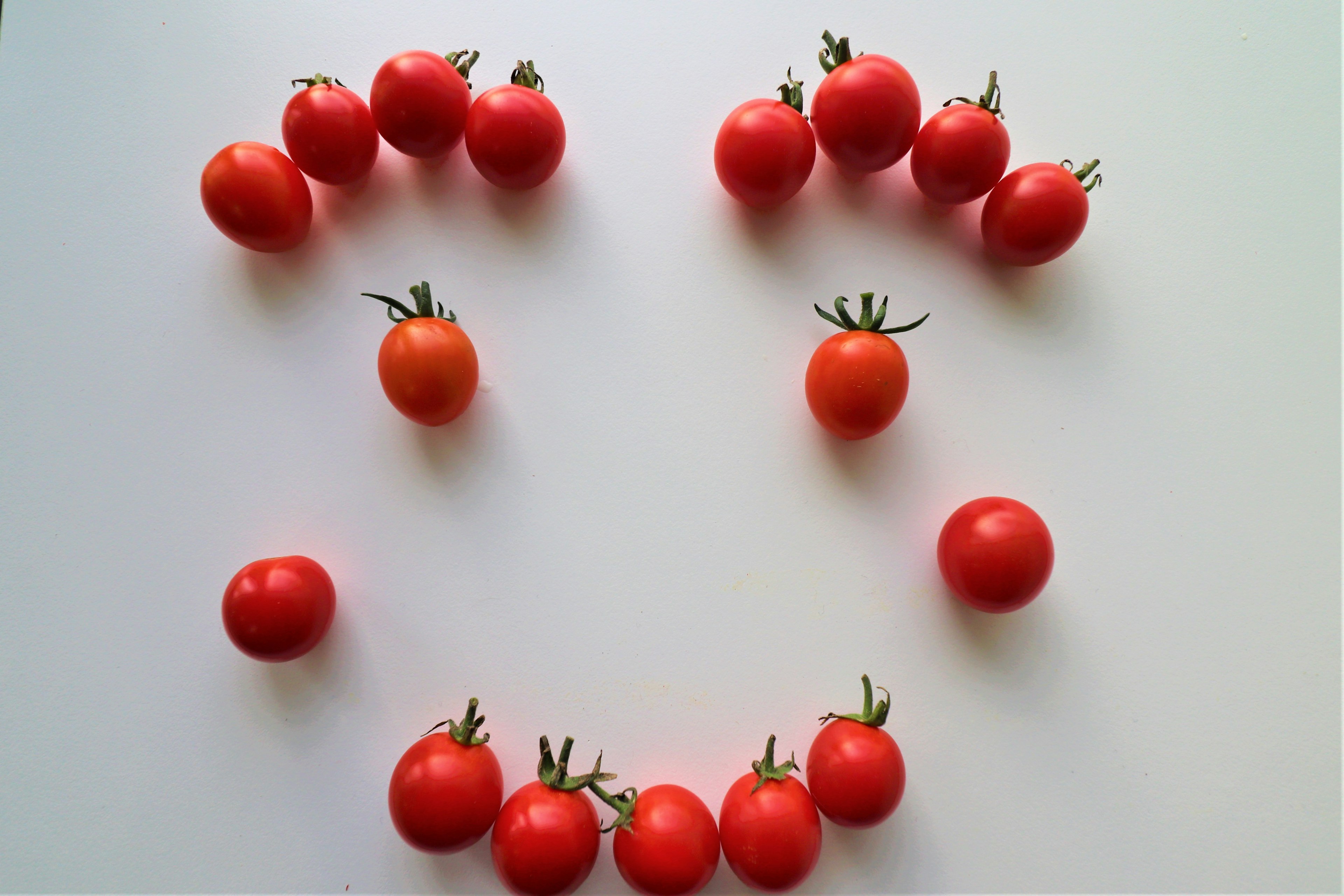 Una cara sonriente hecha de tomates rojos