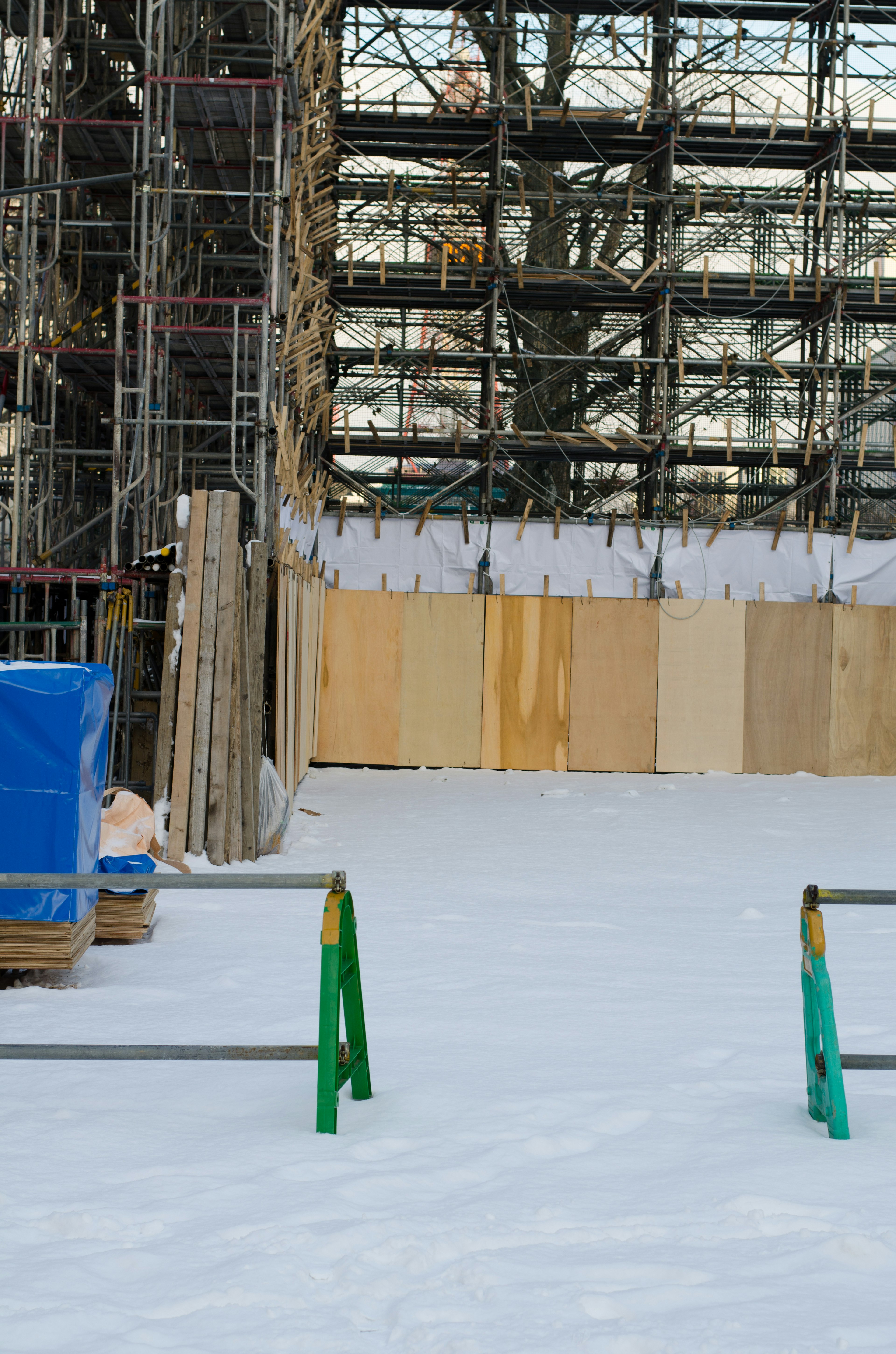 Chantier de construction avec échafaudage et sol recouvert de neige