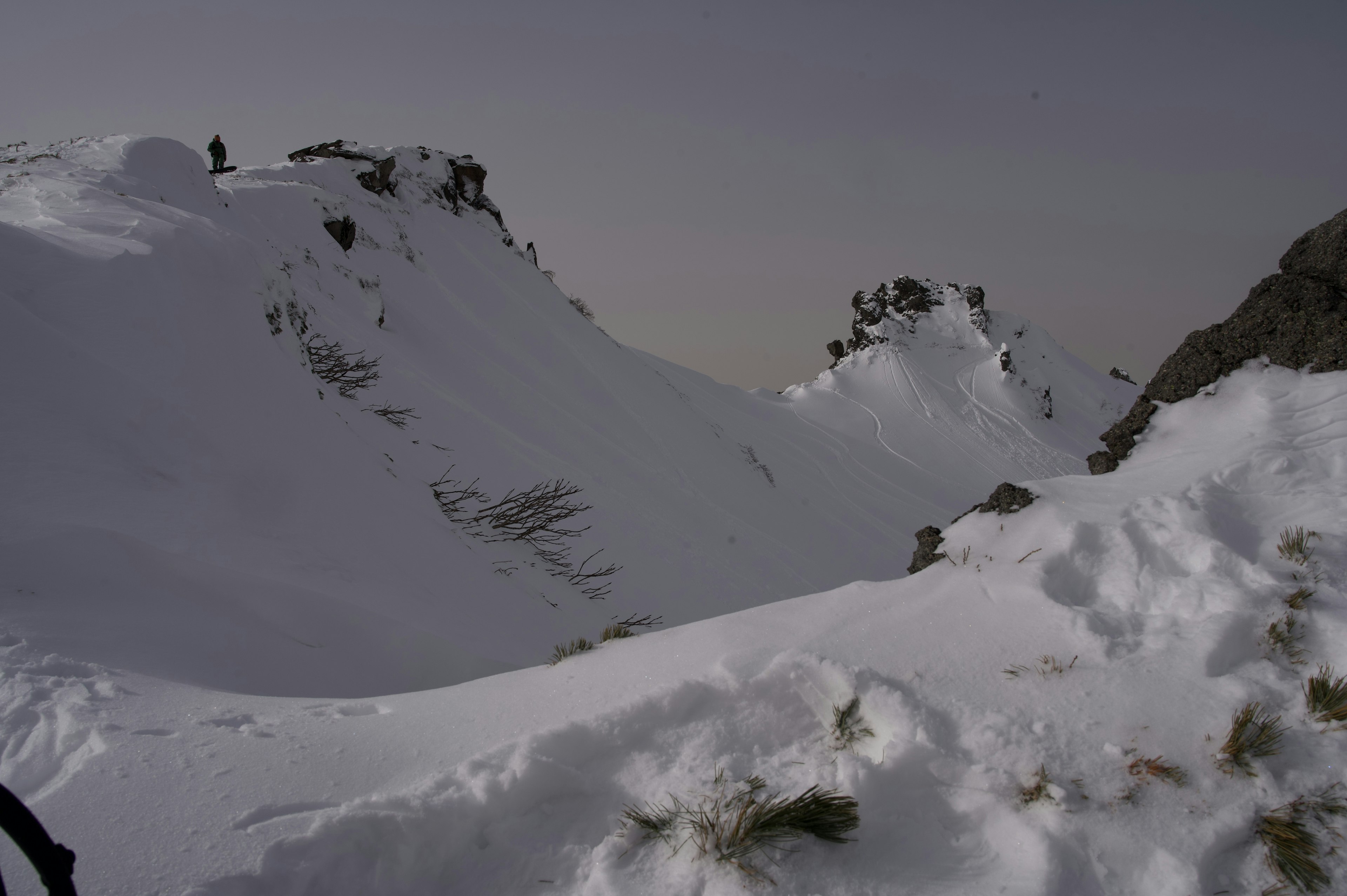 Paisaje montañoso cubierto de nieve con un escalador