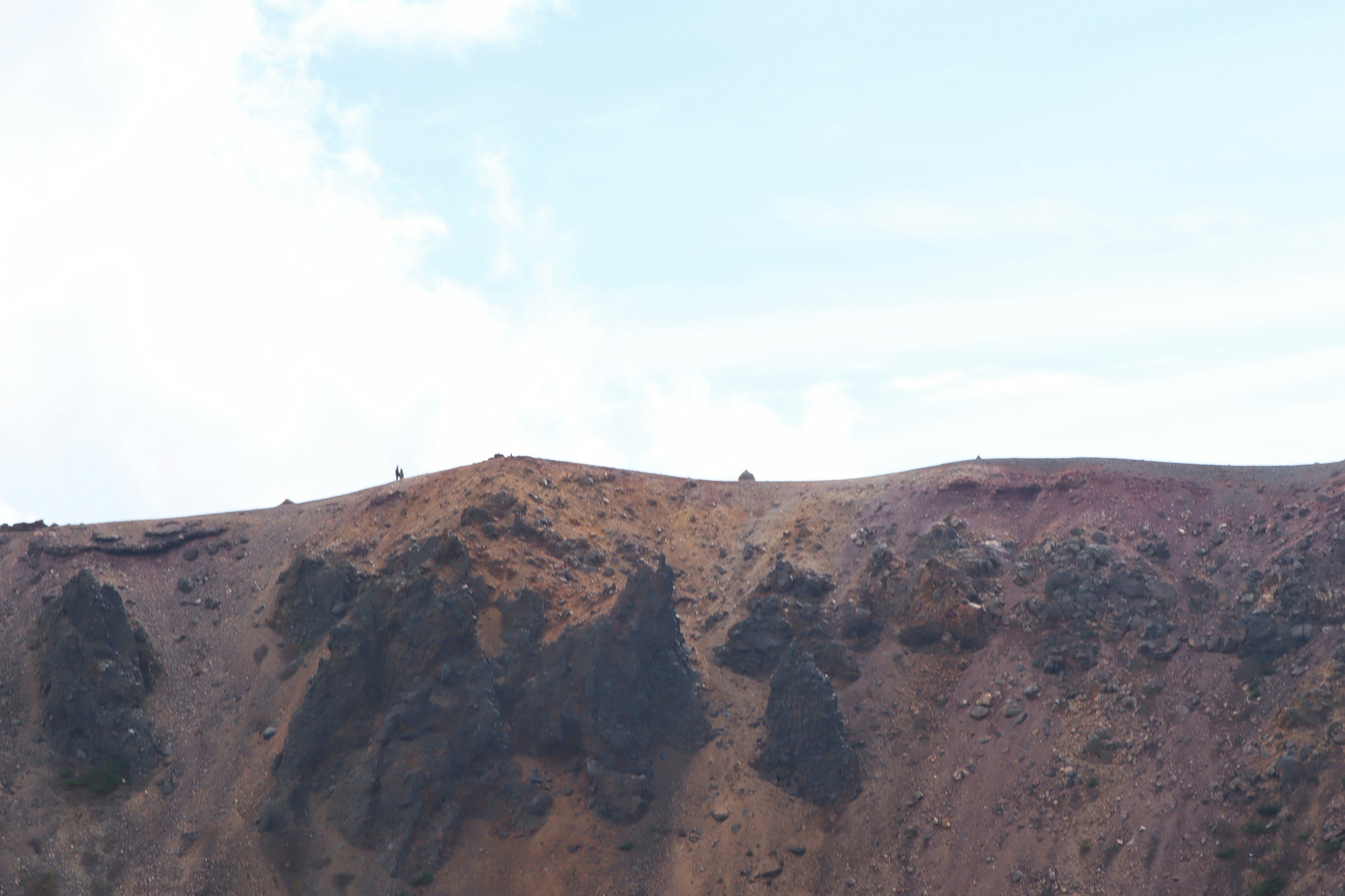 A view of a volcanic crater with a clear blue sky