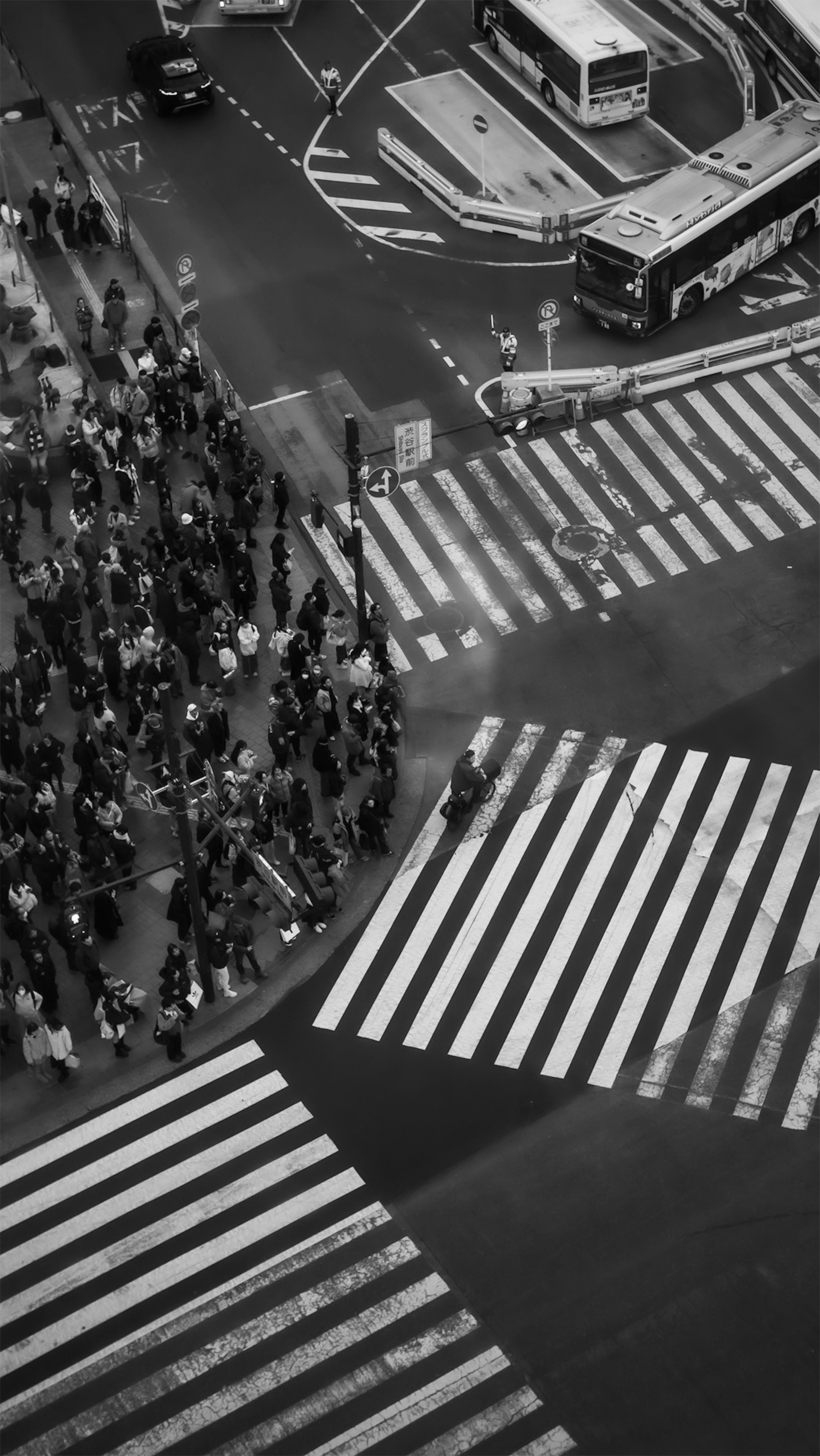 Aerial view of a busy intersection with pedestrians and crosswalks in black and white