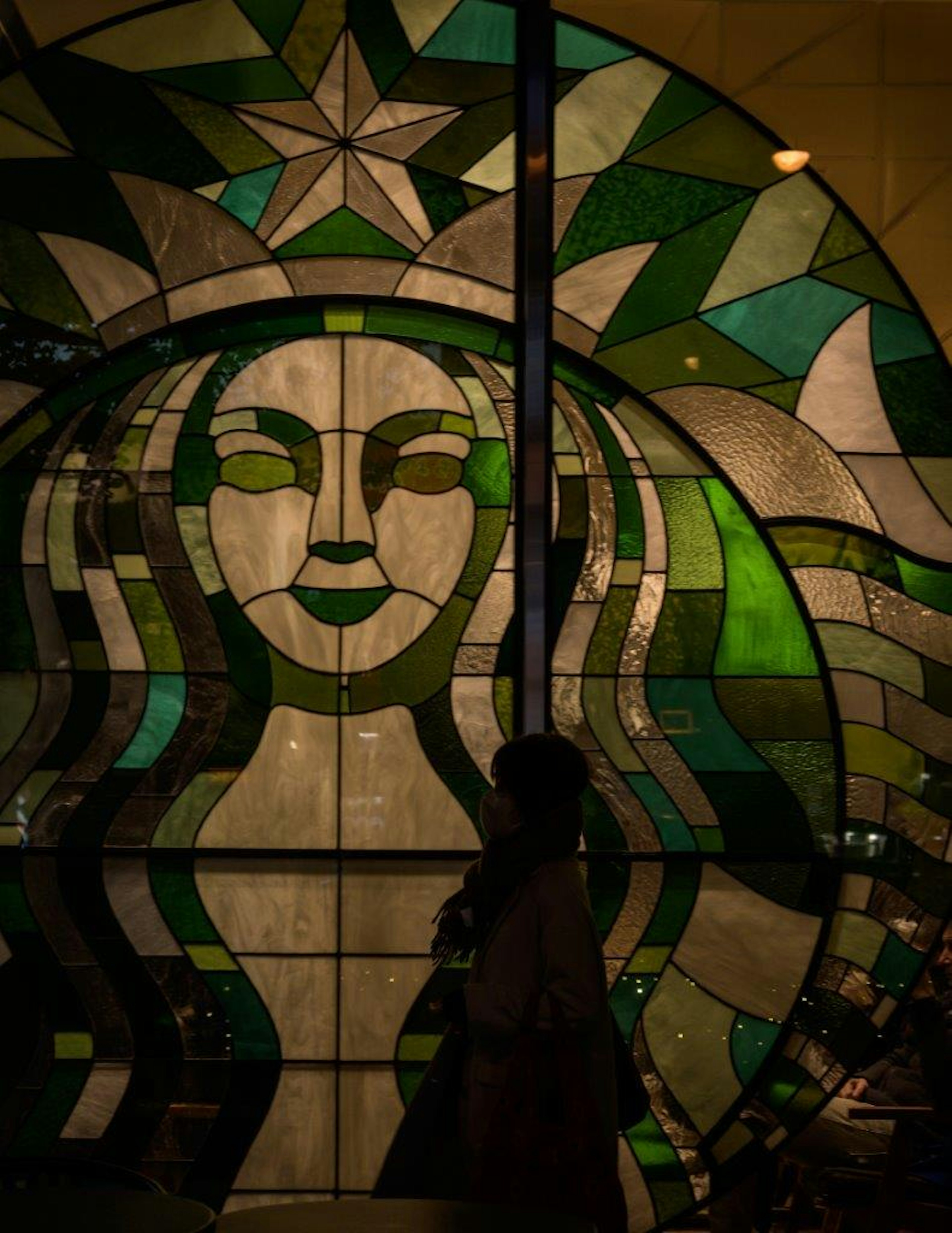 Arte in vetro colorato con il logo Starbucks e la silhouette di una donna