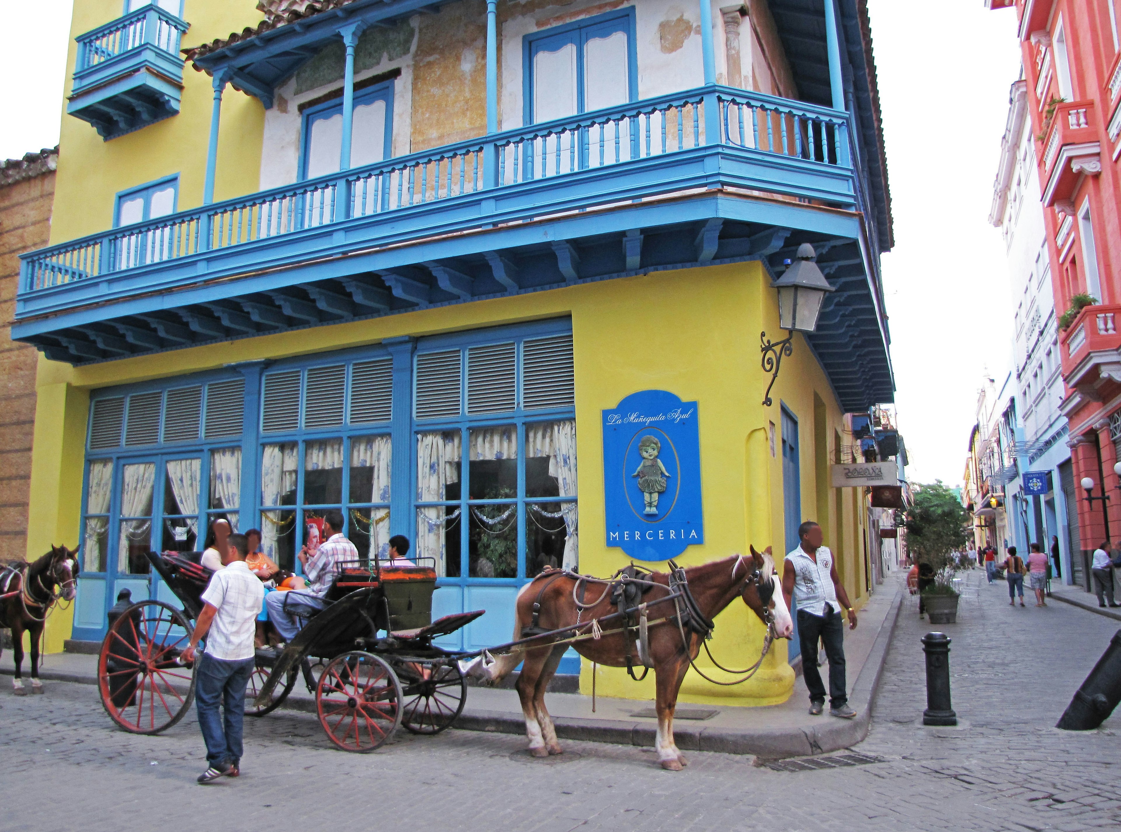 Scena di strada colorata con una carrozza trainata da cavallo e edifici vivaci