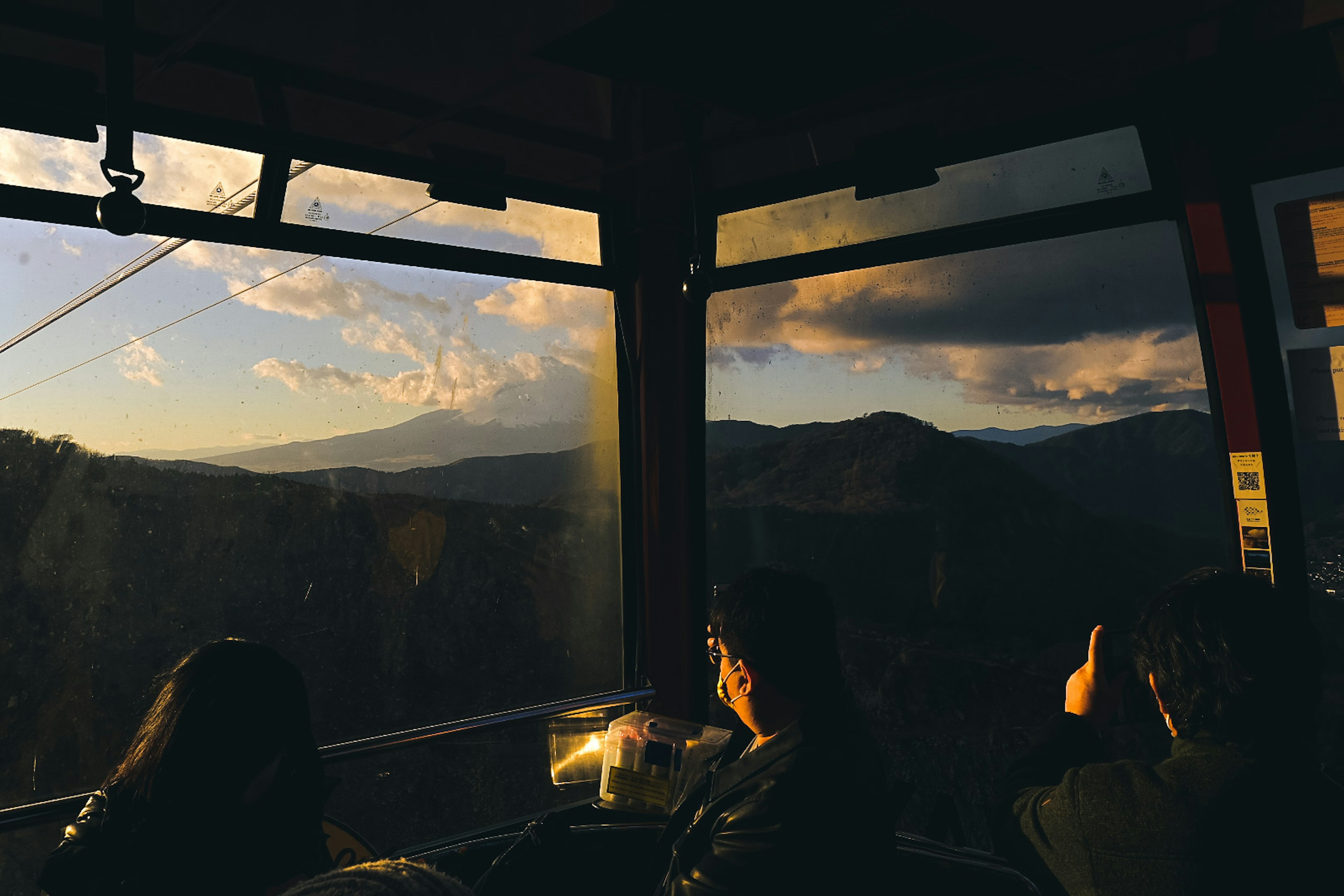 山を背景に夕日を眺める人々の風景