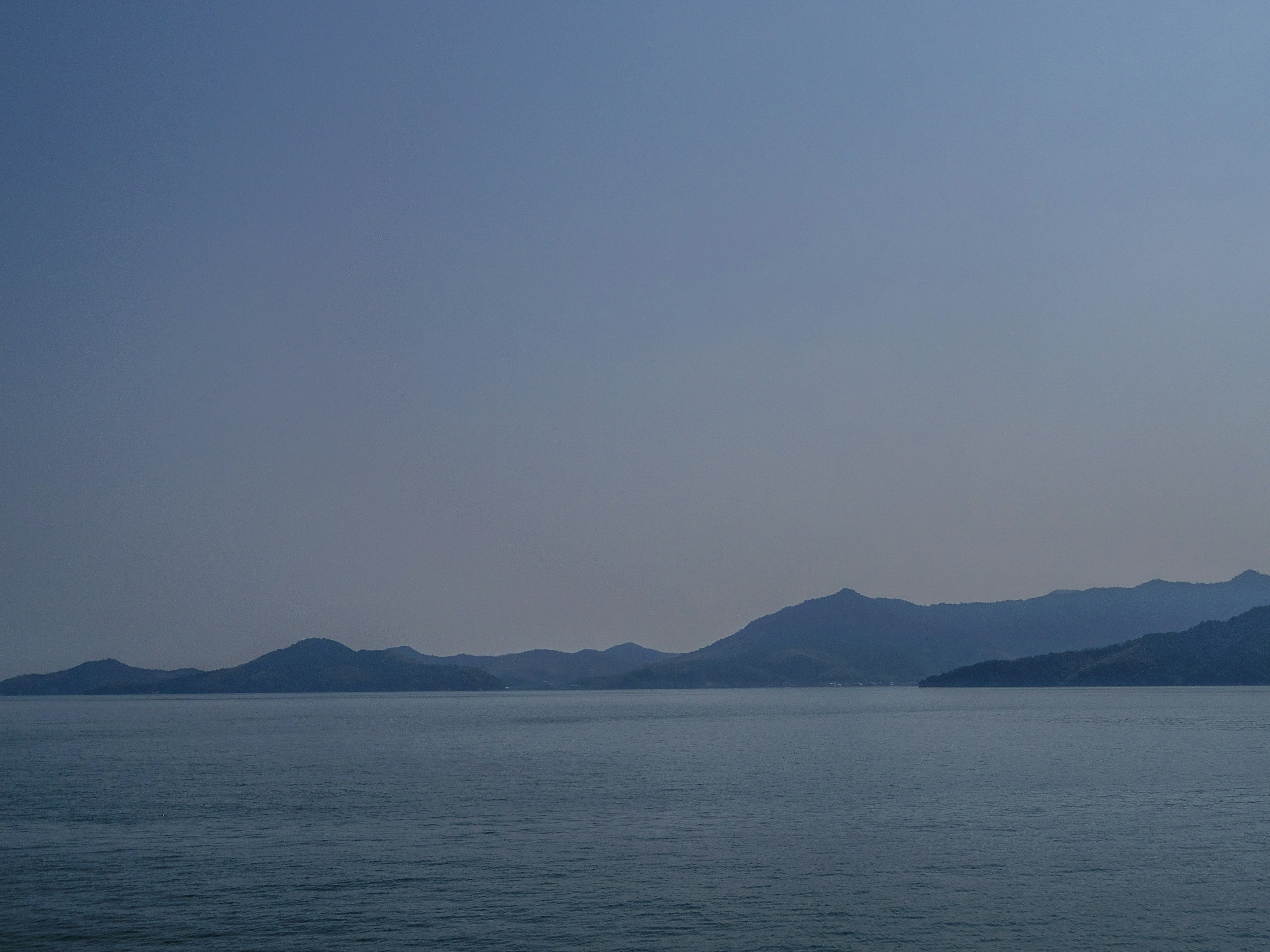 Serene view of calm sea and blue mountains