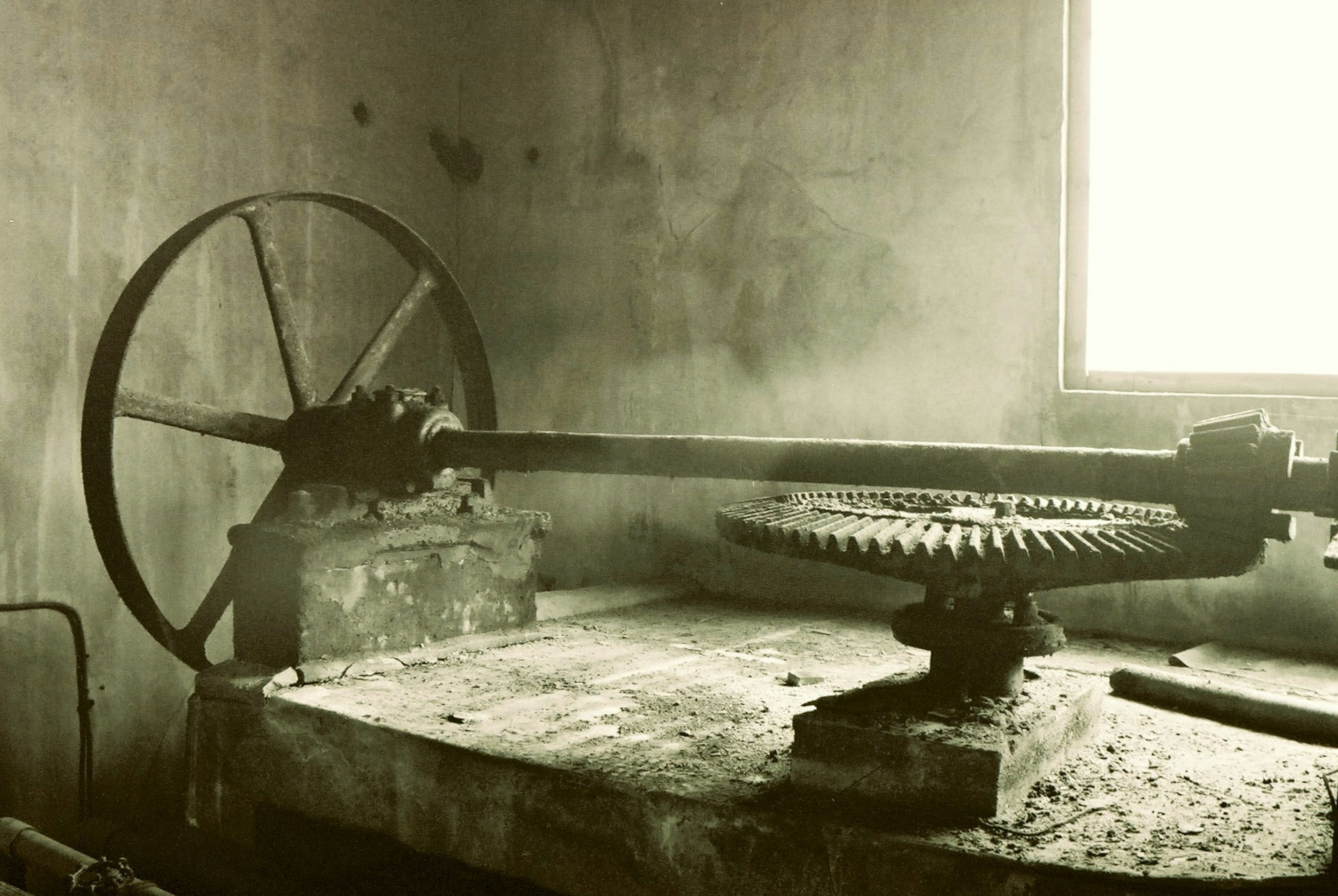 Old factory interior featuring gears and a large wheel