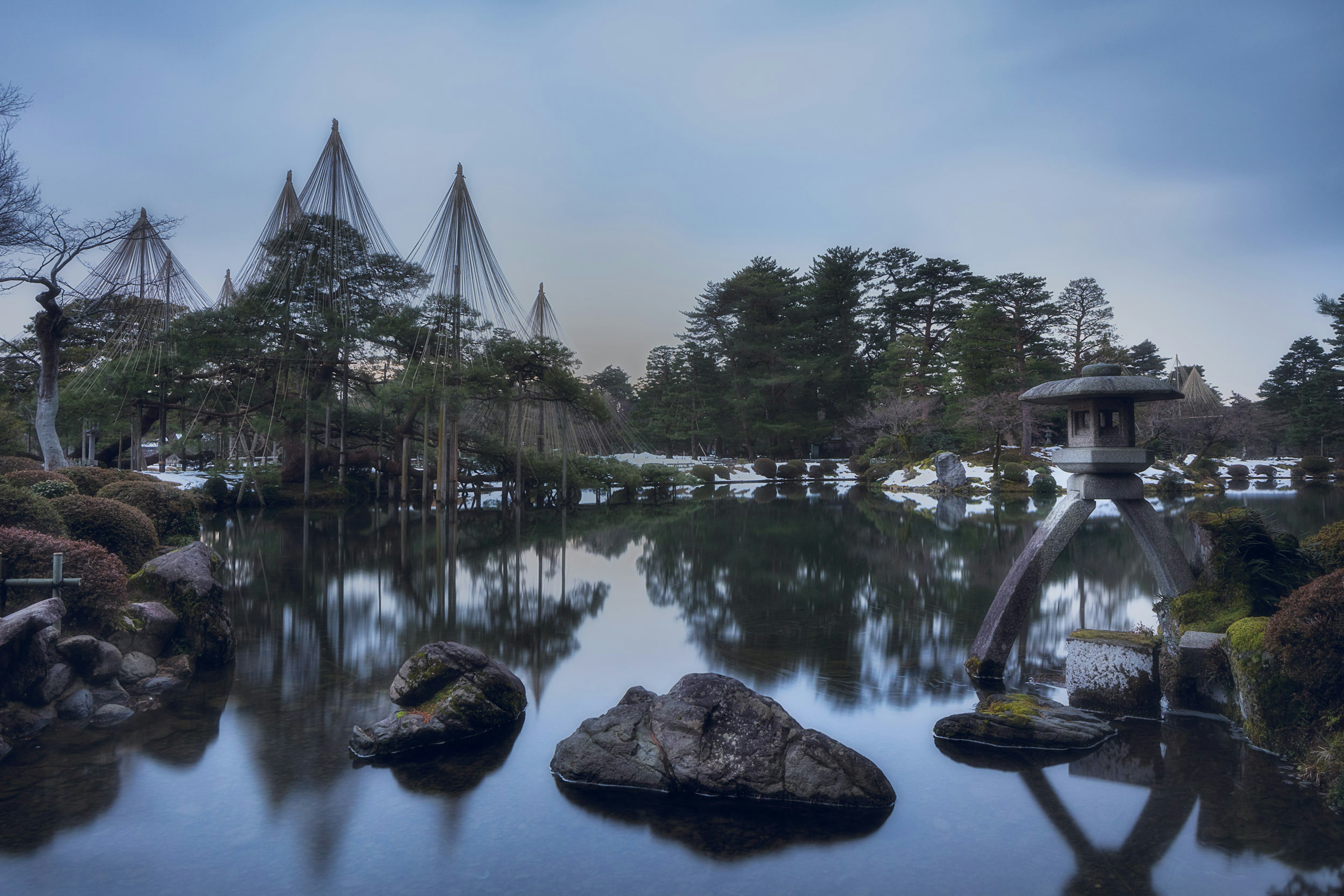 Jardín japonés tranquilo con un estanque y formaciones rocosas