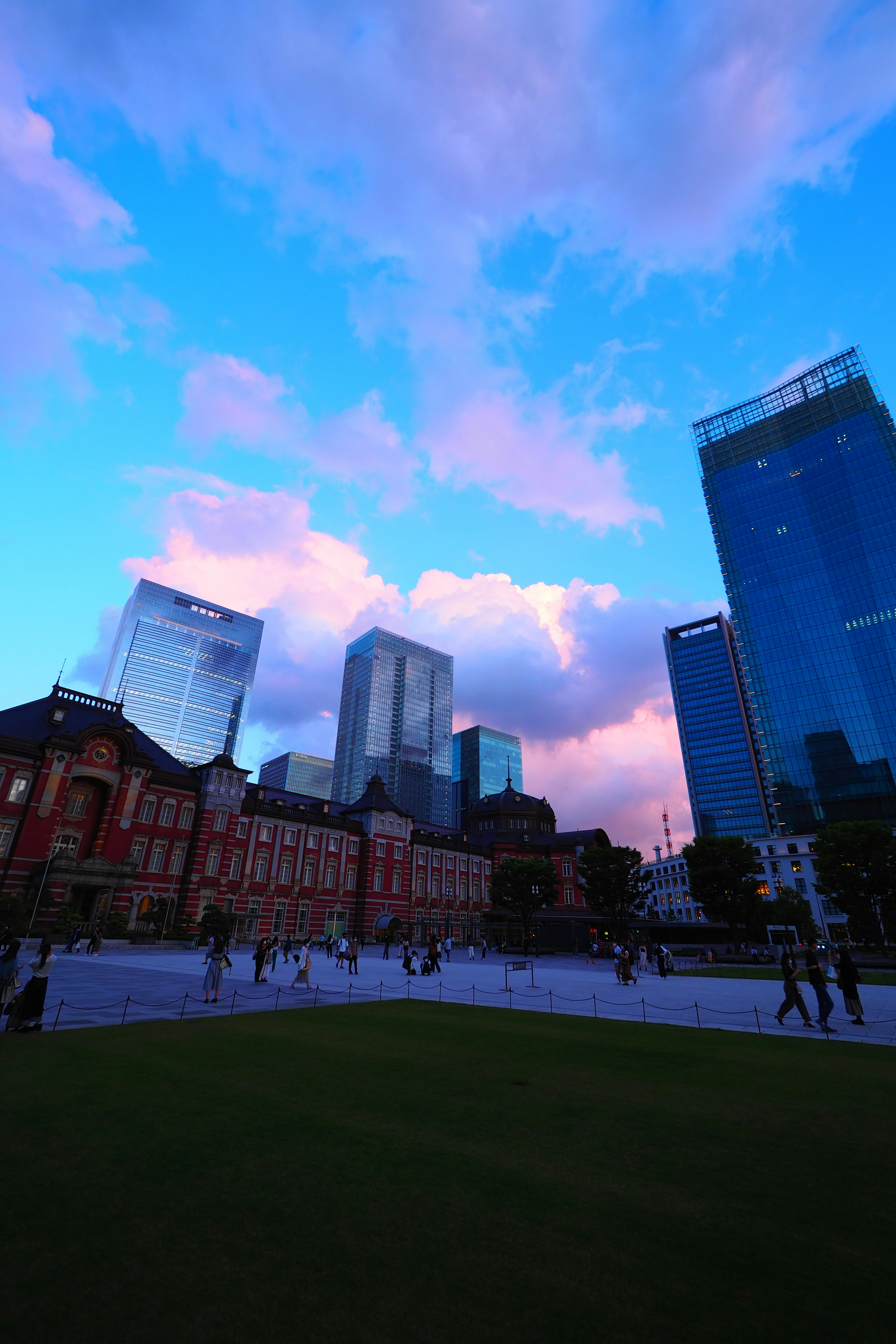 Estación de Tokio con rascacielos al atardecer