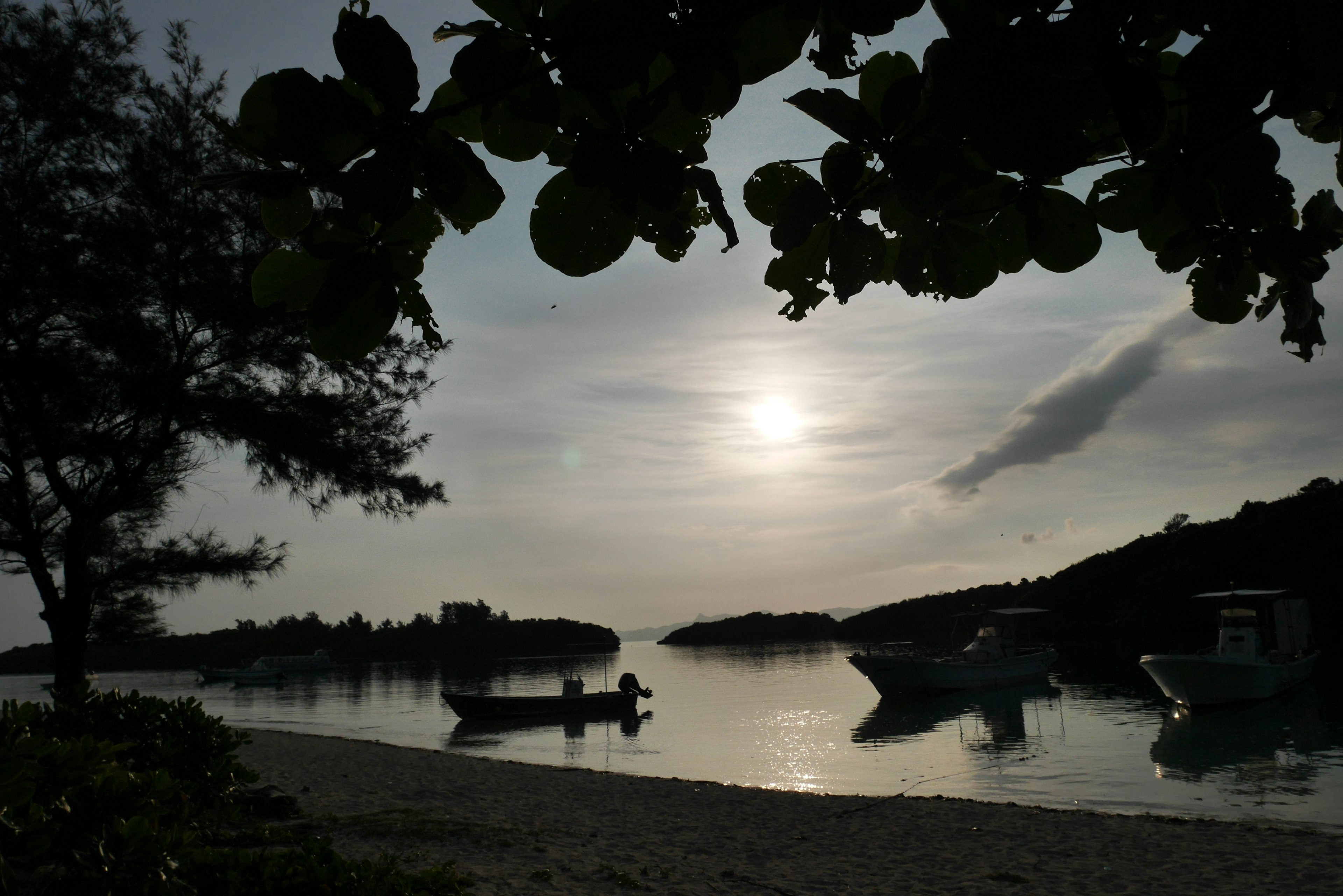 静かな海辺に浮かぶボートと穏やかな夕日