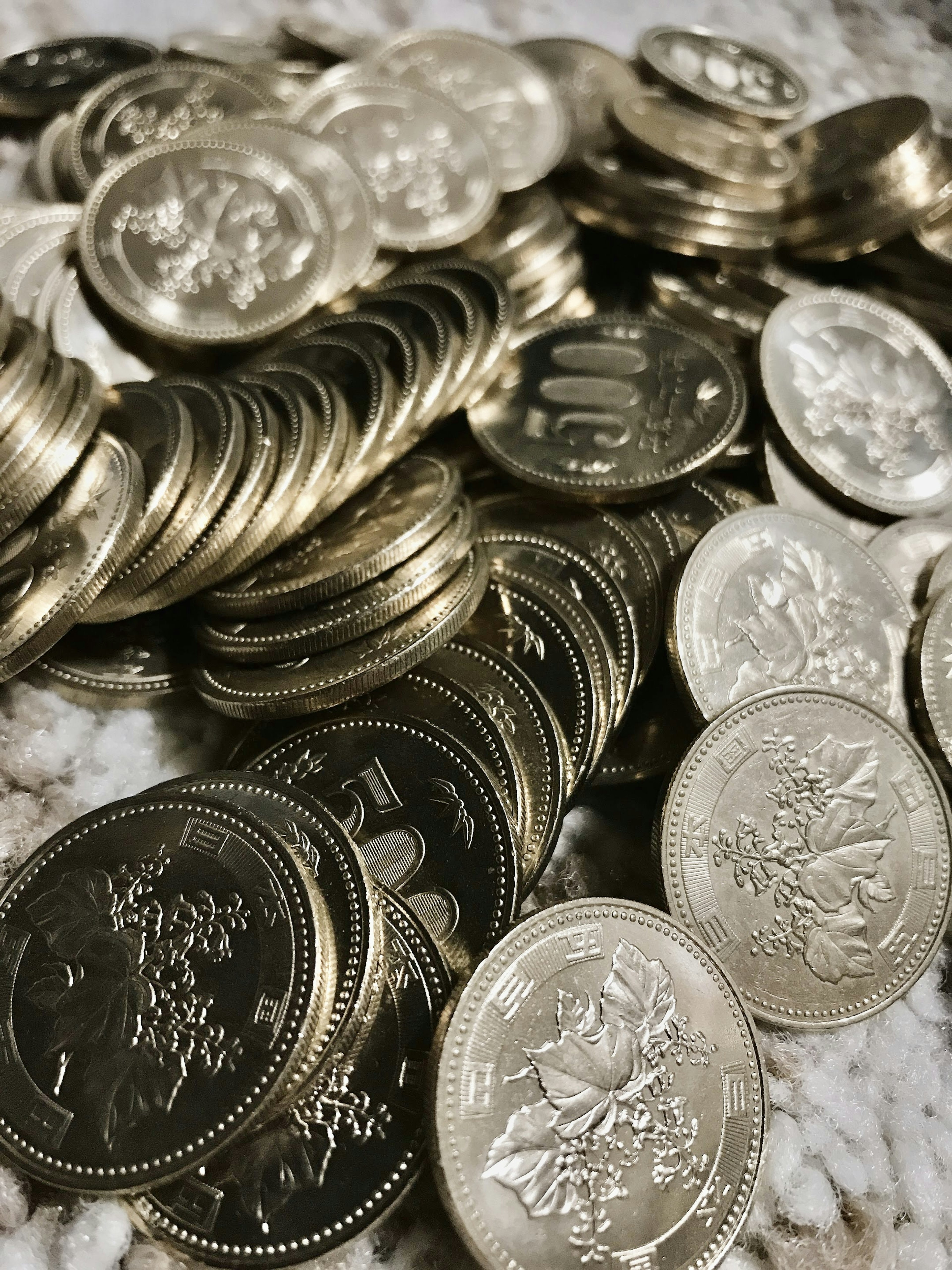 A pile of silver coins scattered on a surface