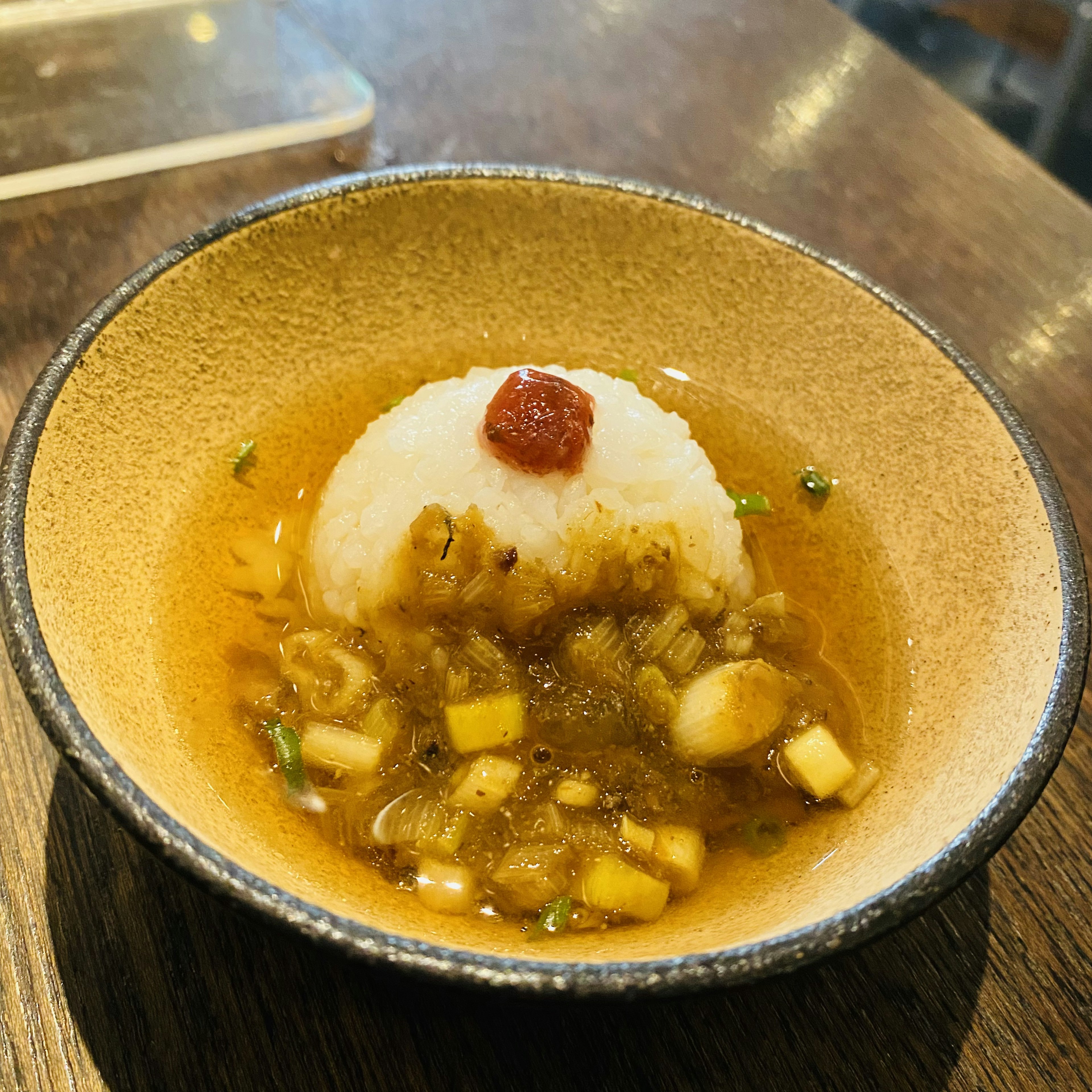 Tazón con arroz cubierto con un condimento rojo en caldo