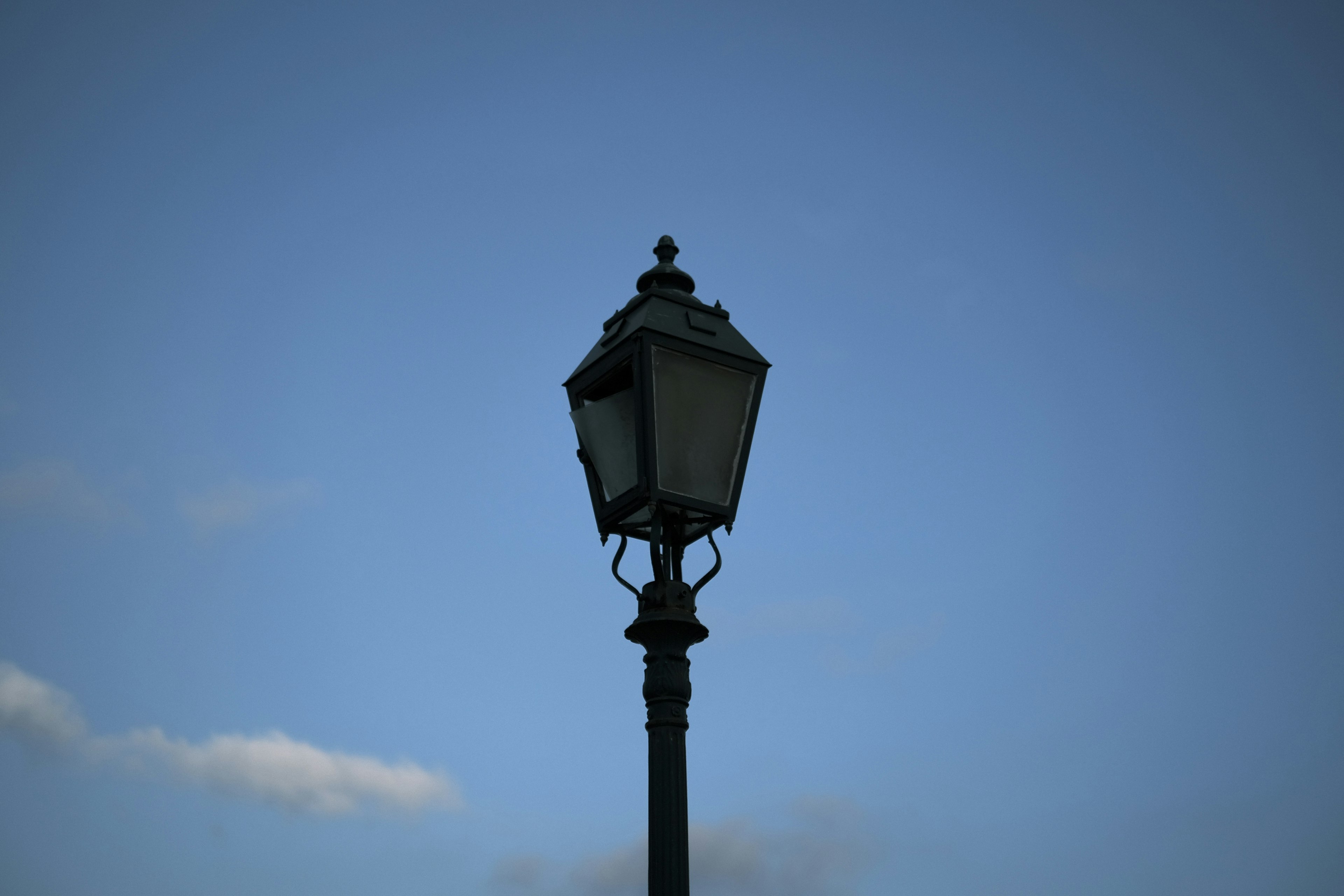 A vintage street lamp against a blue sky