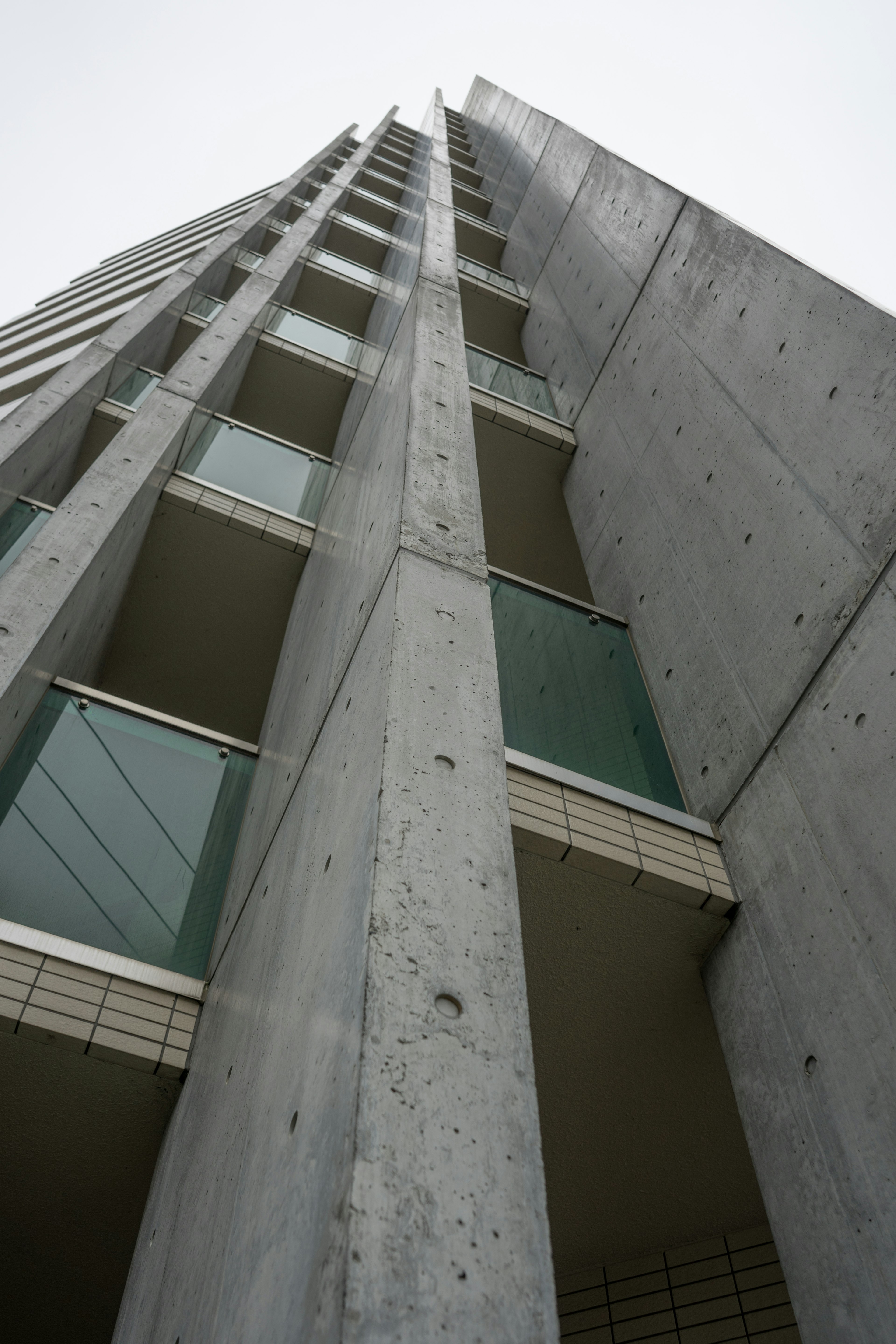 A tall concrete building viewed from below showcasing its architectural features