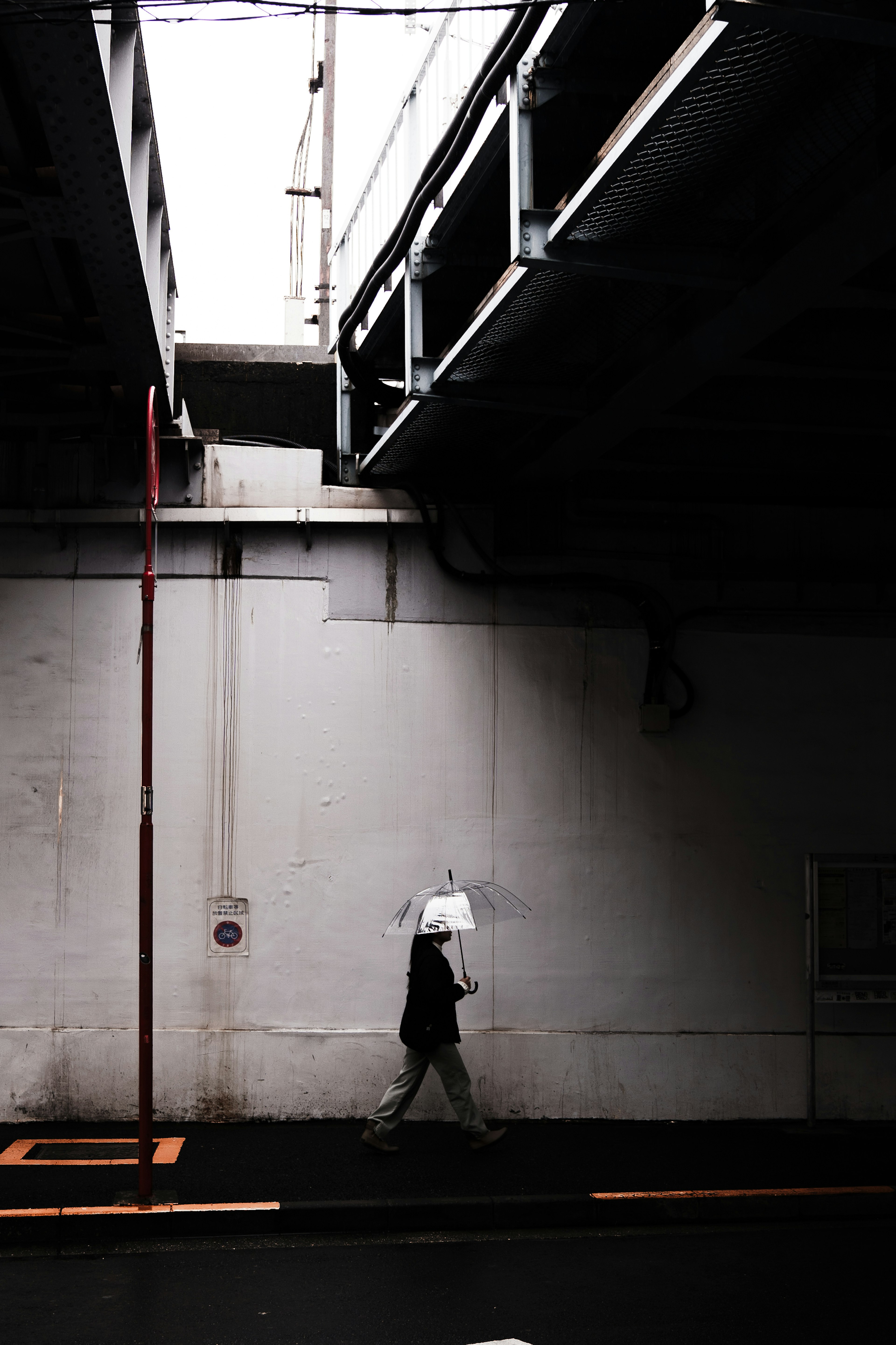 Person wearing a white hat walking in an underpass