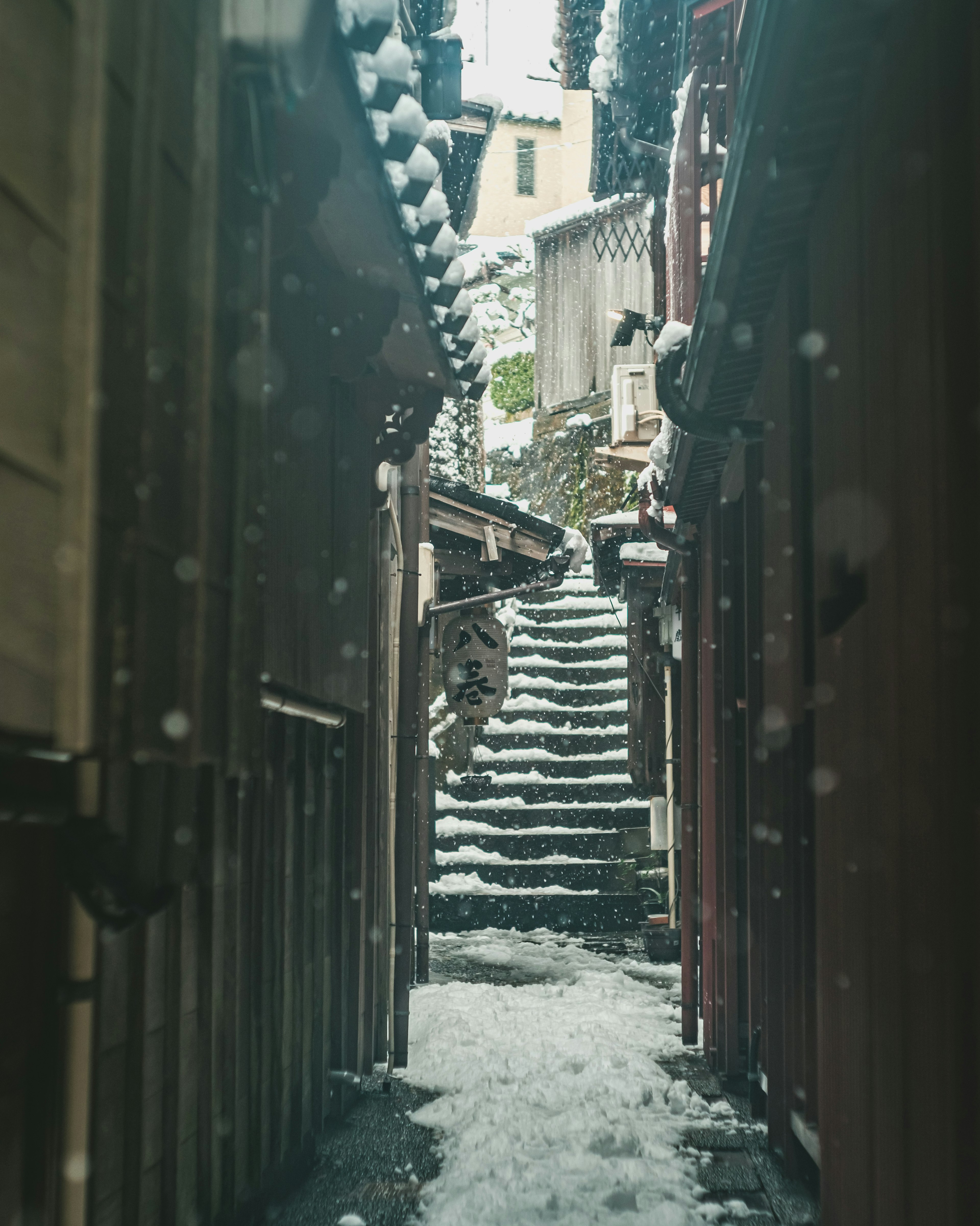 Callejón estrecho con escaleras cubiertas de nieve