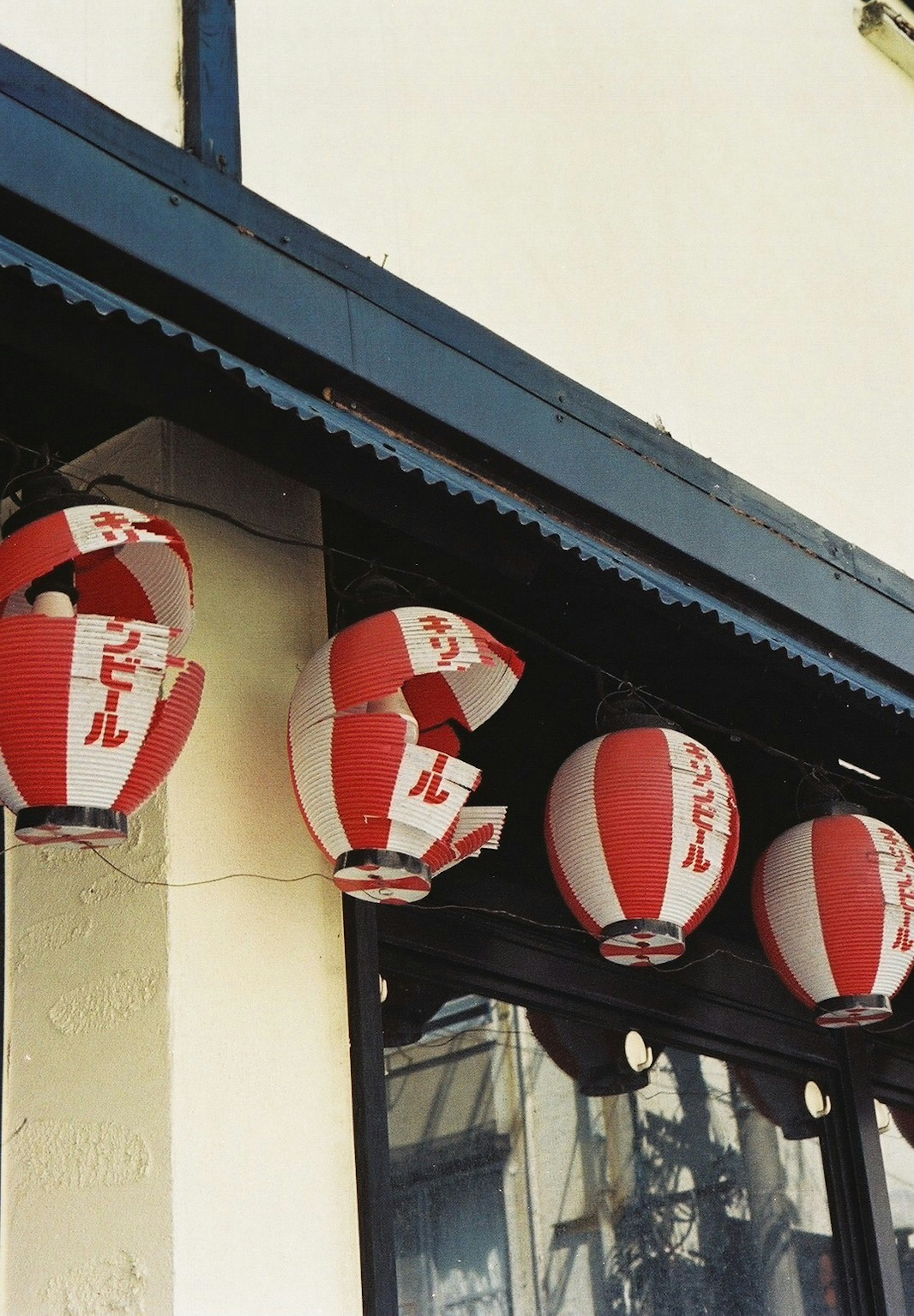 Red and white paper lanterns hanging under a roof