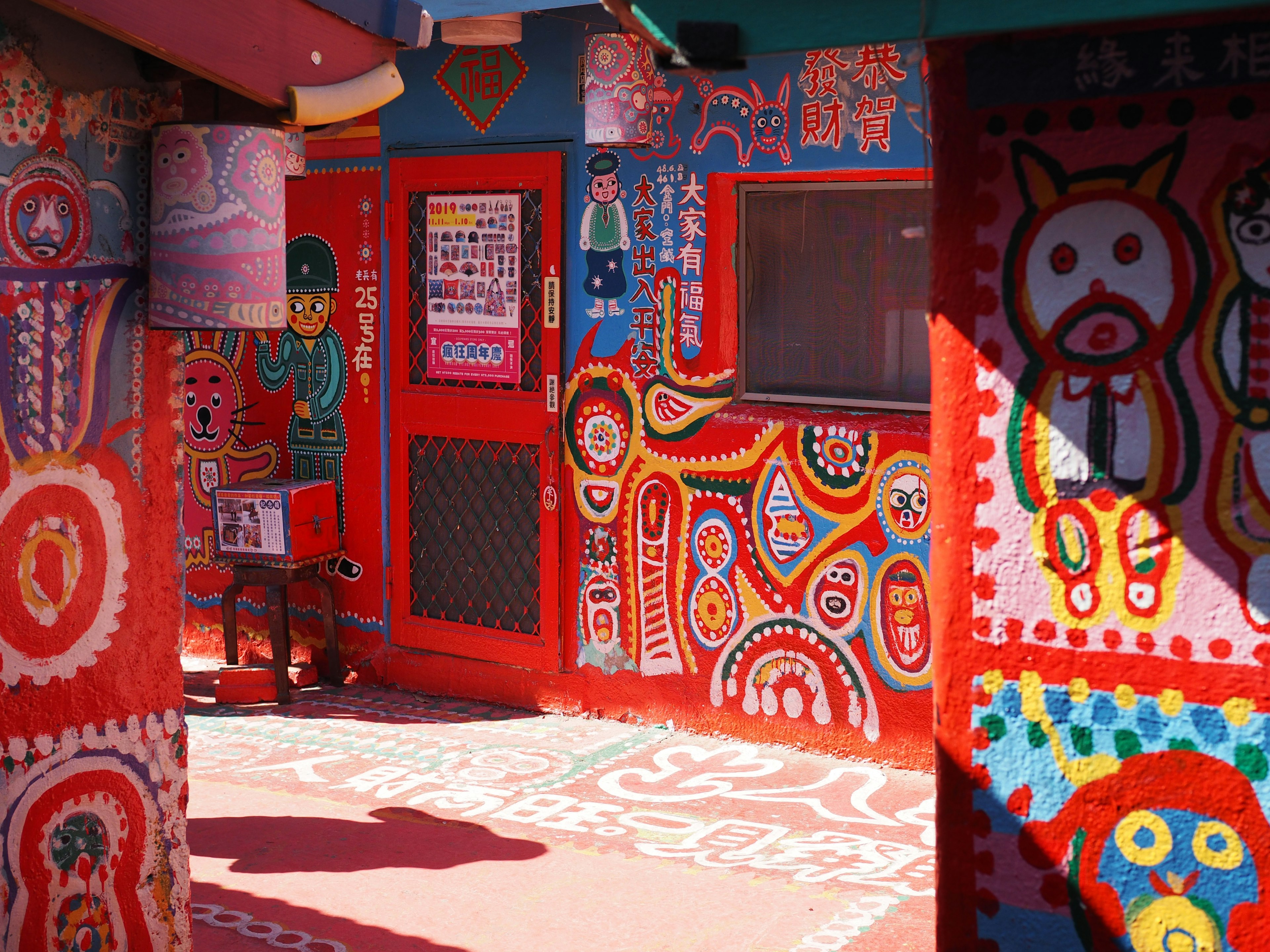 Edificio rojo vibrante con murales coloridos y una entrada acogedora