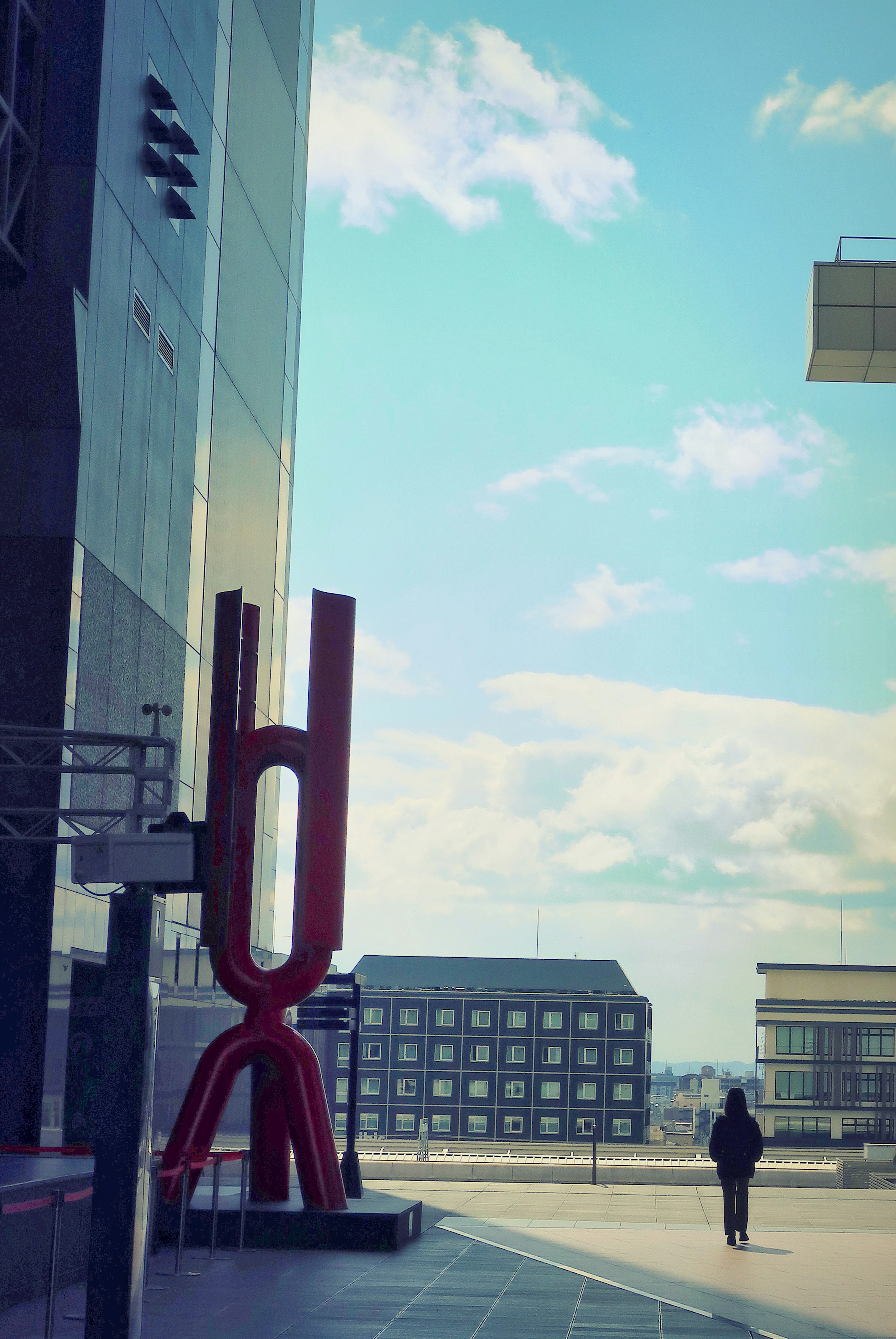 Vista di una piazza con una scultura rossa e edifici moderni