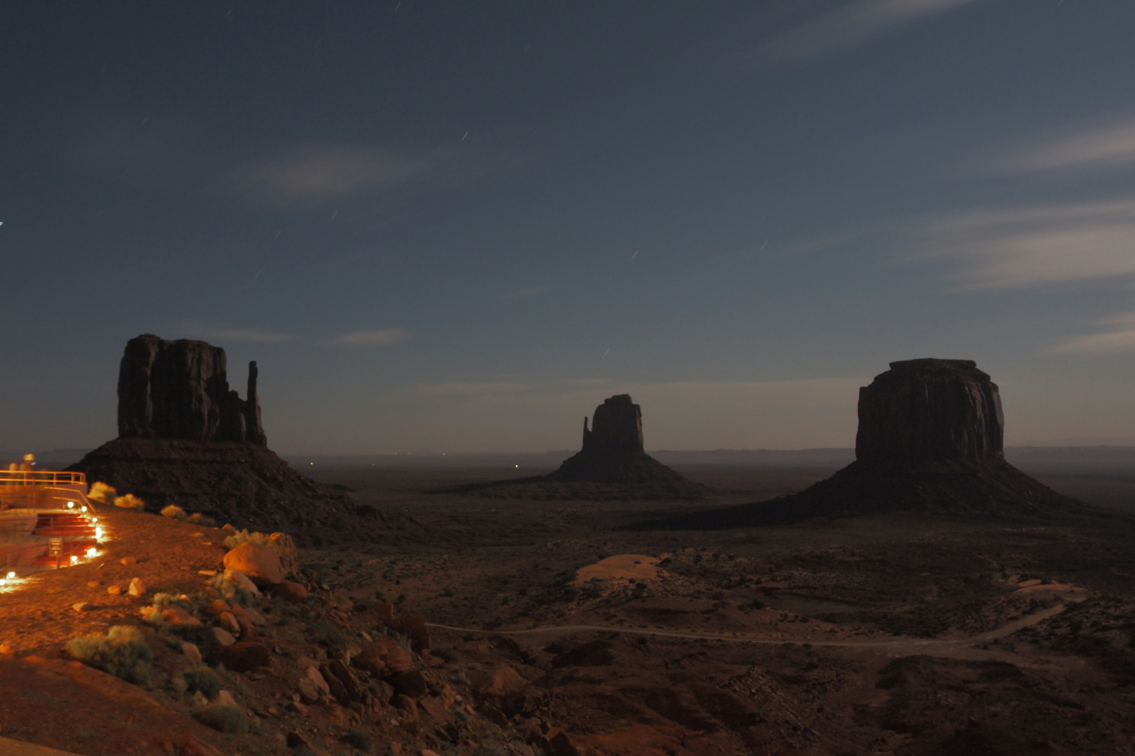 ทิวทัศน์ยามค่ำคืนของ Monument Valley ที่มีหินสามก้อนส่องสว่างโดยแสงจันทร์