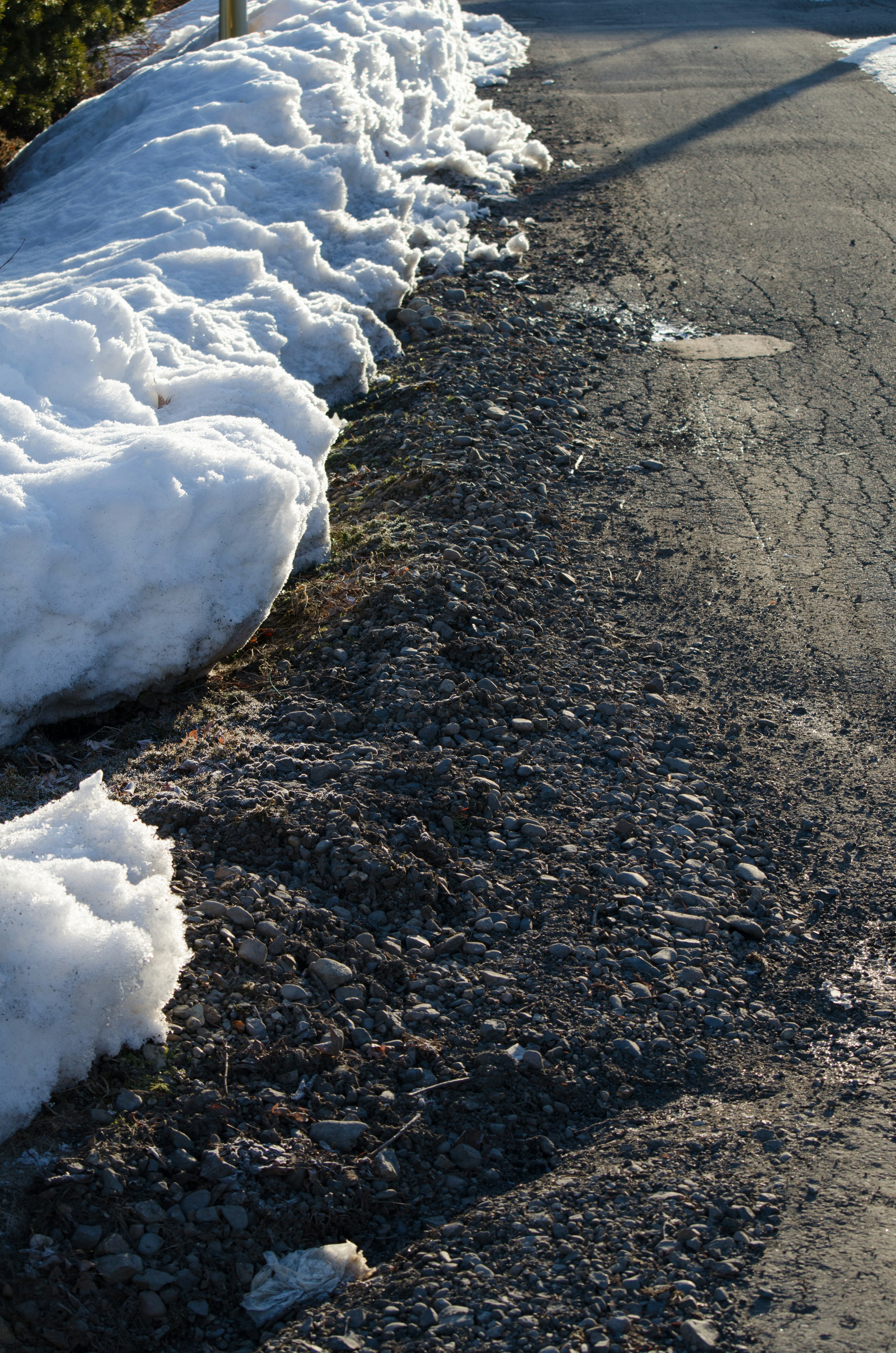 Gravel path beside a snowy roadside