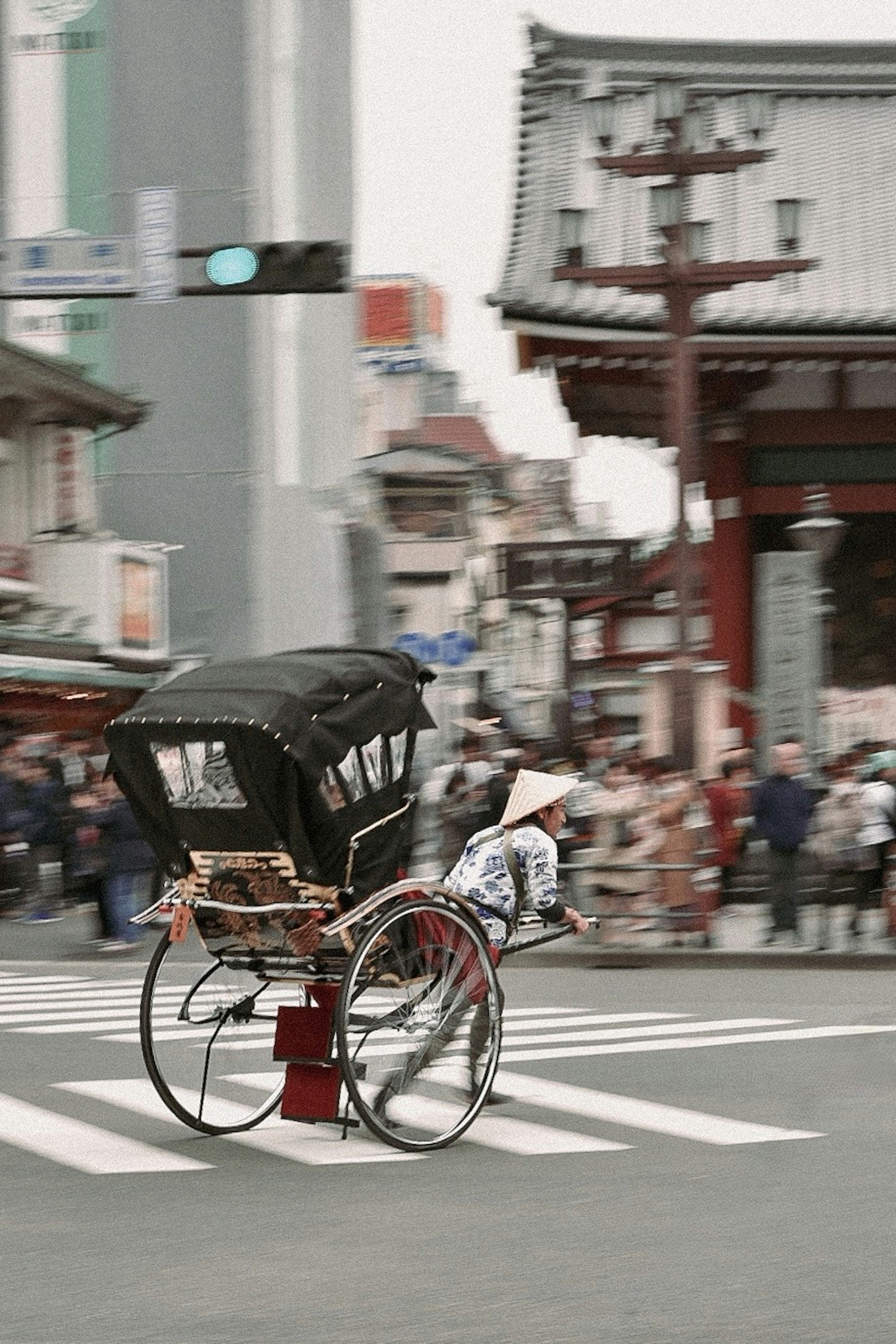 Rickshaw cruzando la intersección con arquitectura tradicional de fondo