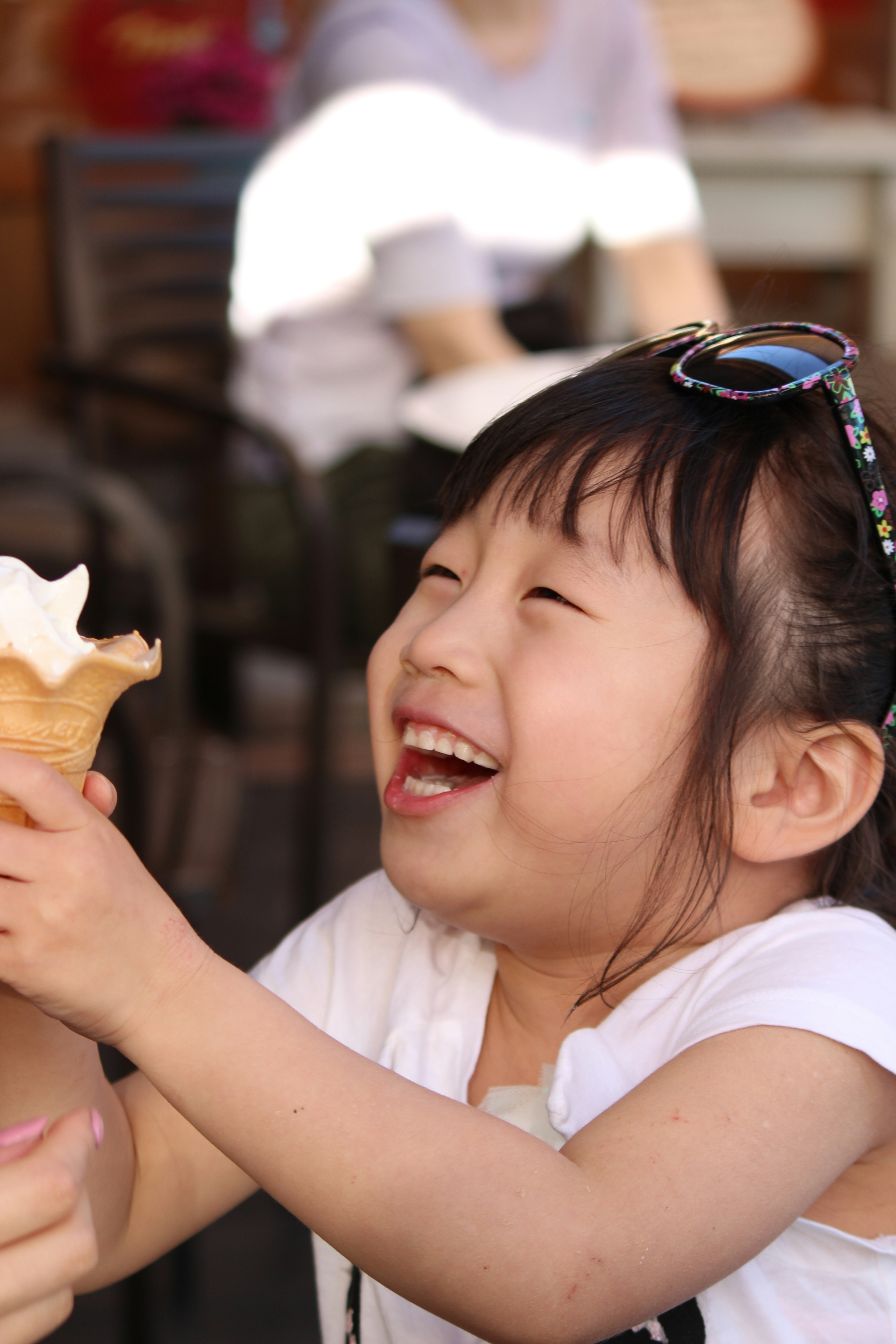 Fille riant en tenant un cornet de glace