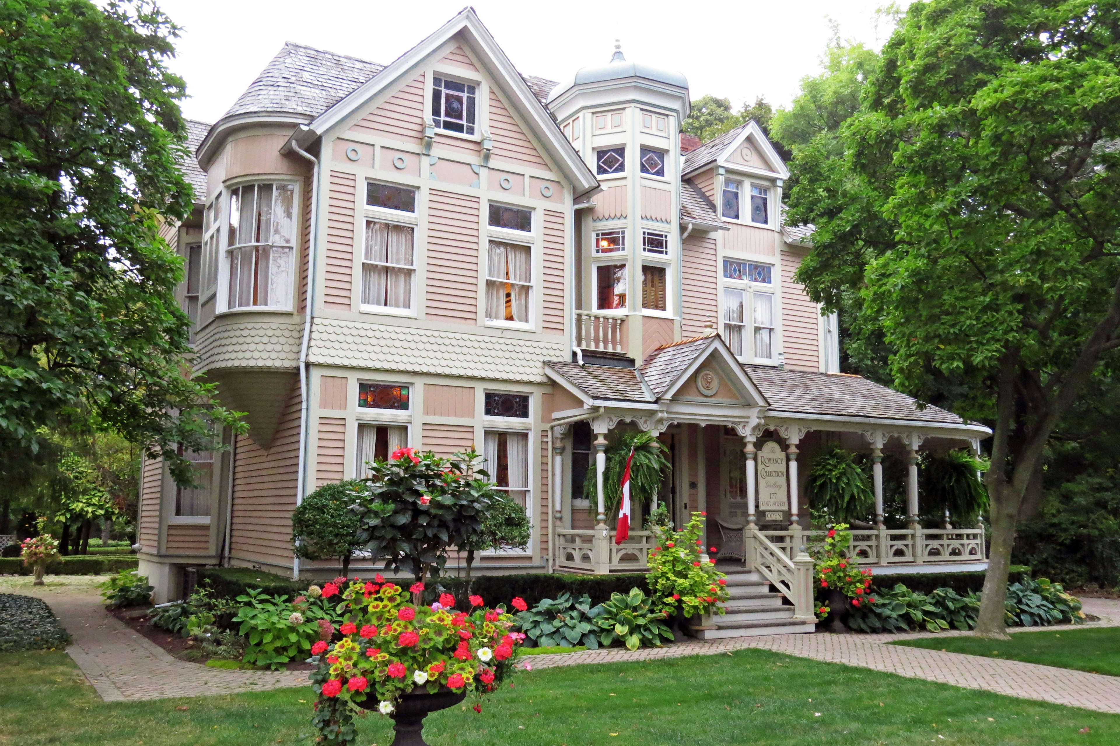 Beautiful Victorian-style house exterior featuring lush gardens and flowers