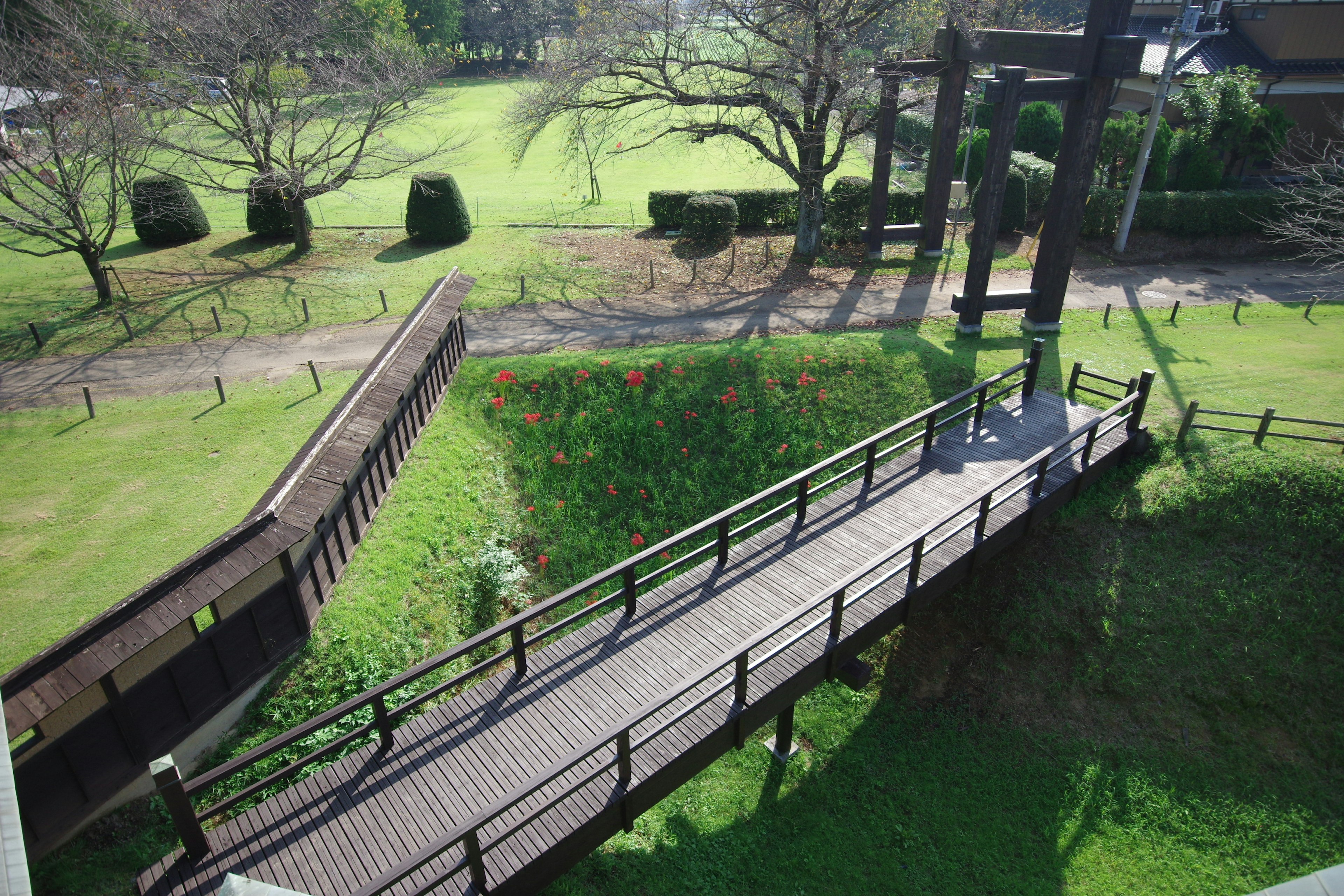 Wooden bridge spanning a green park with surrounding landscape