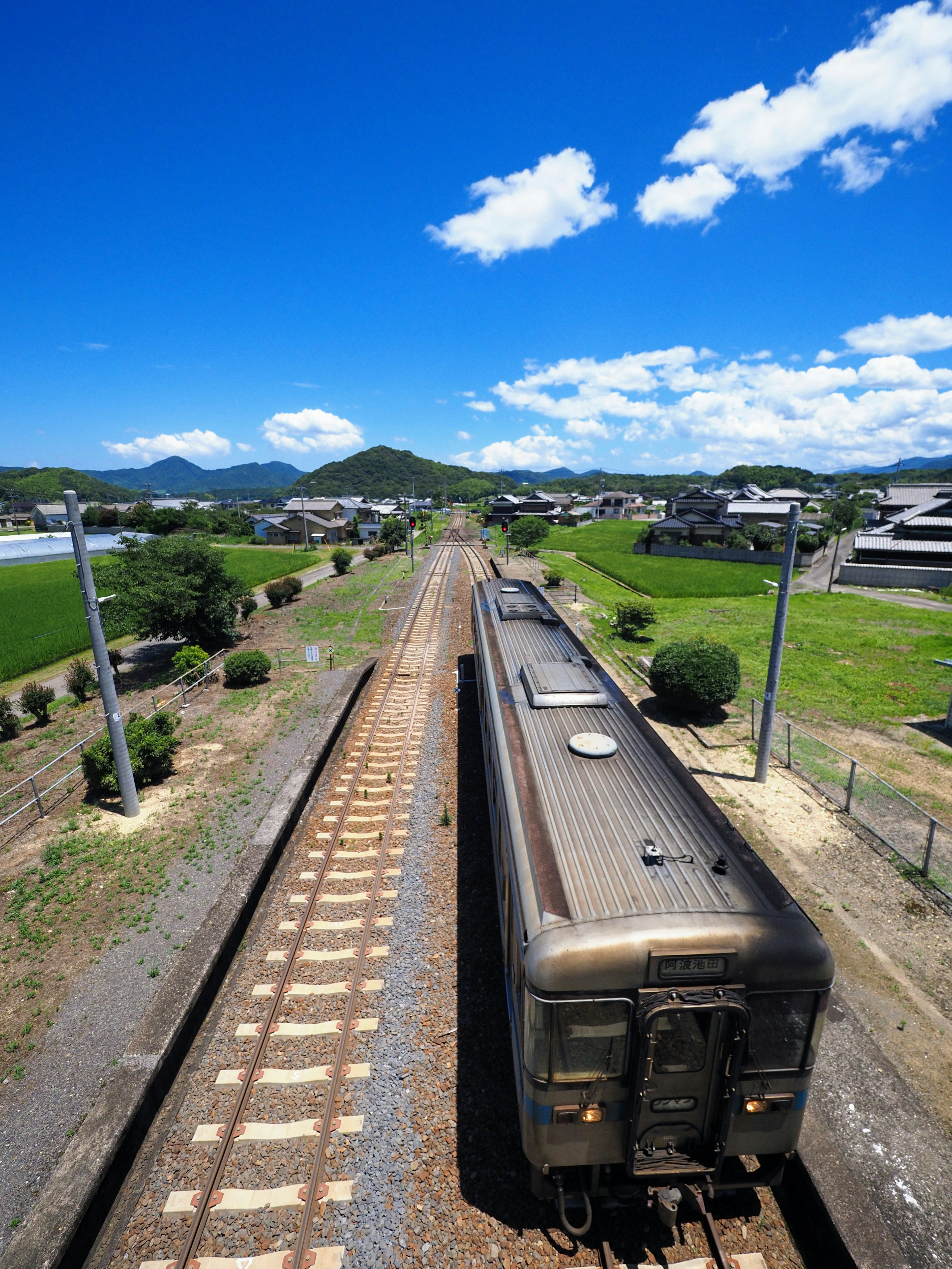 Aerial view of a train car with a rural landscape and blue sky