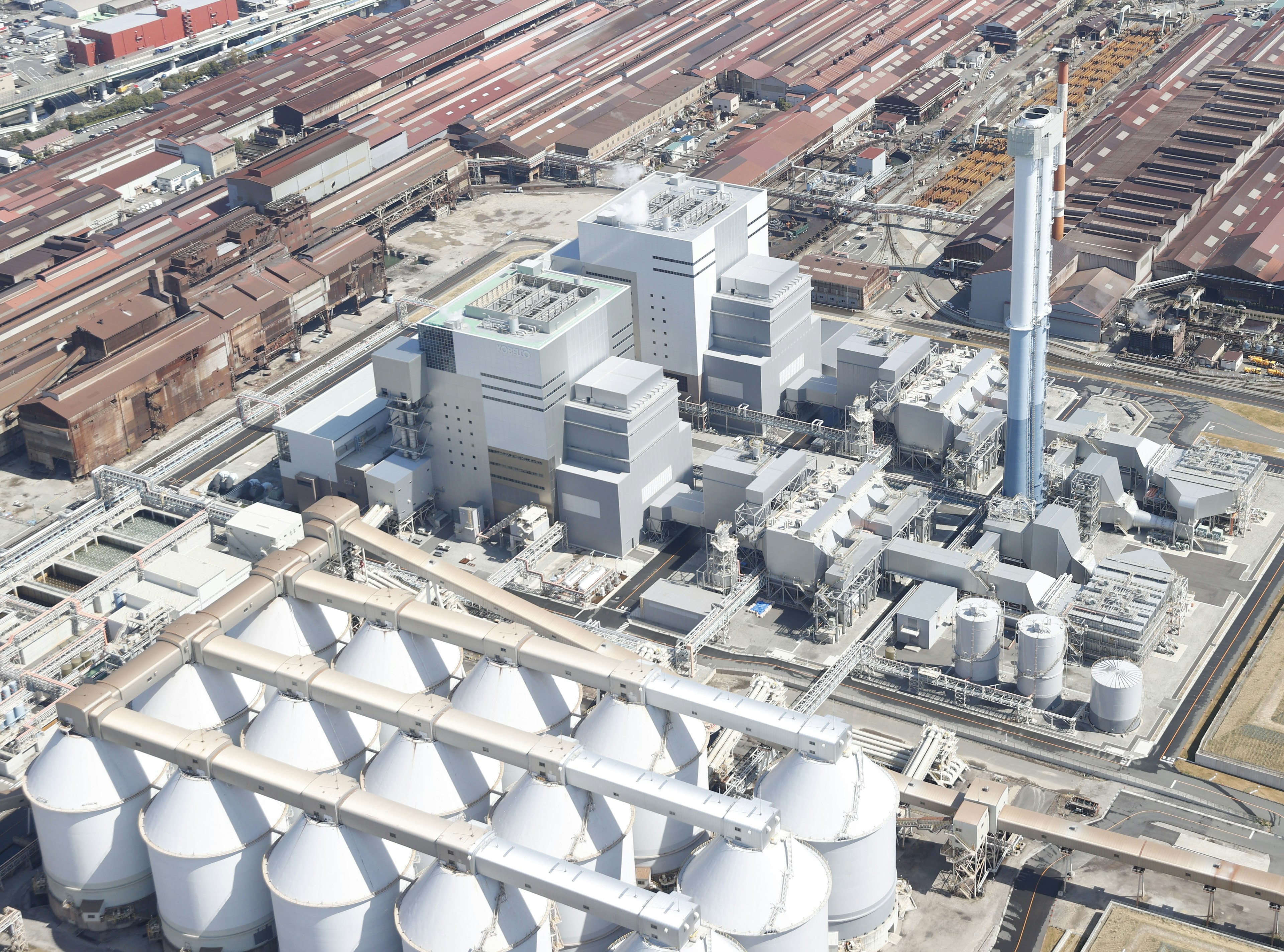 Vue aérienne d'une zone industrielle avec une usine et des silos cylindriques