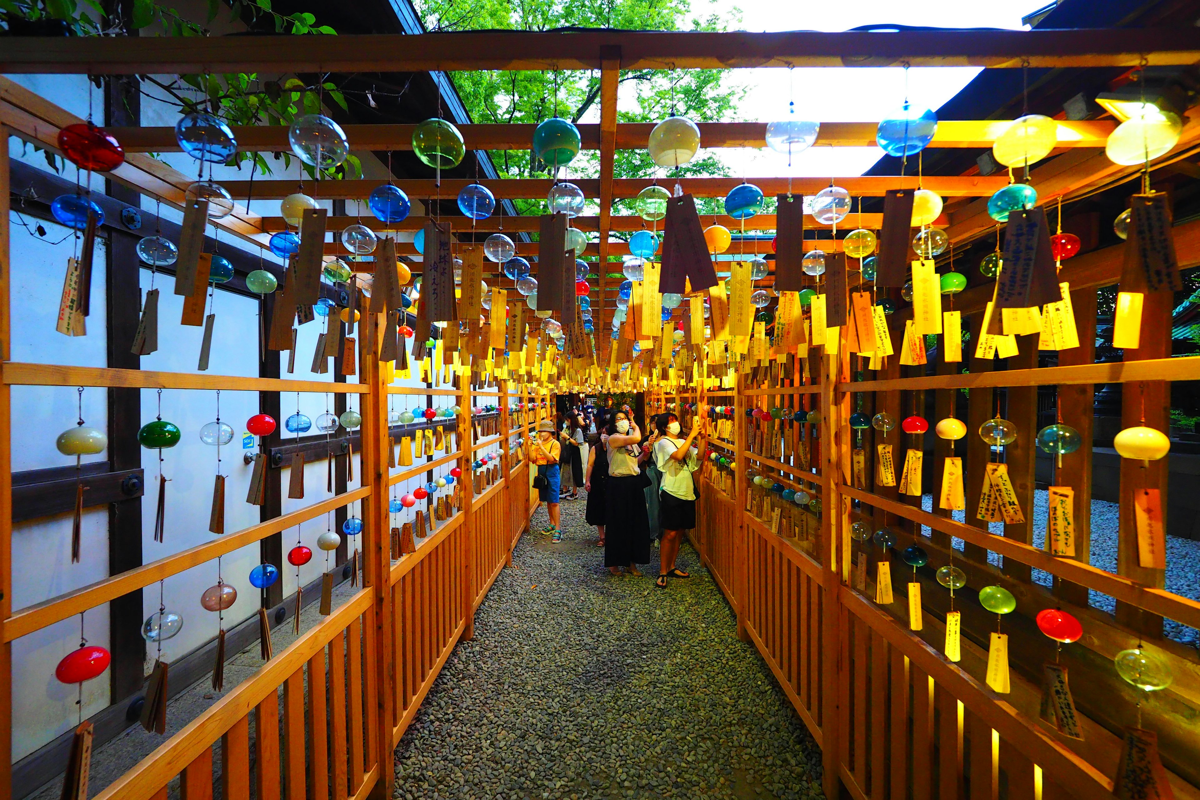 Colorful wind chimes hanging in a traditional Japanese street scene