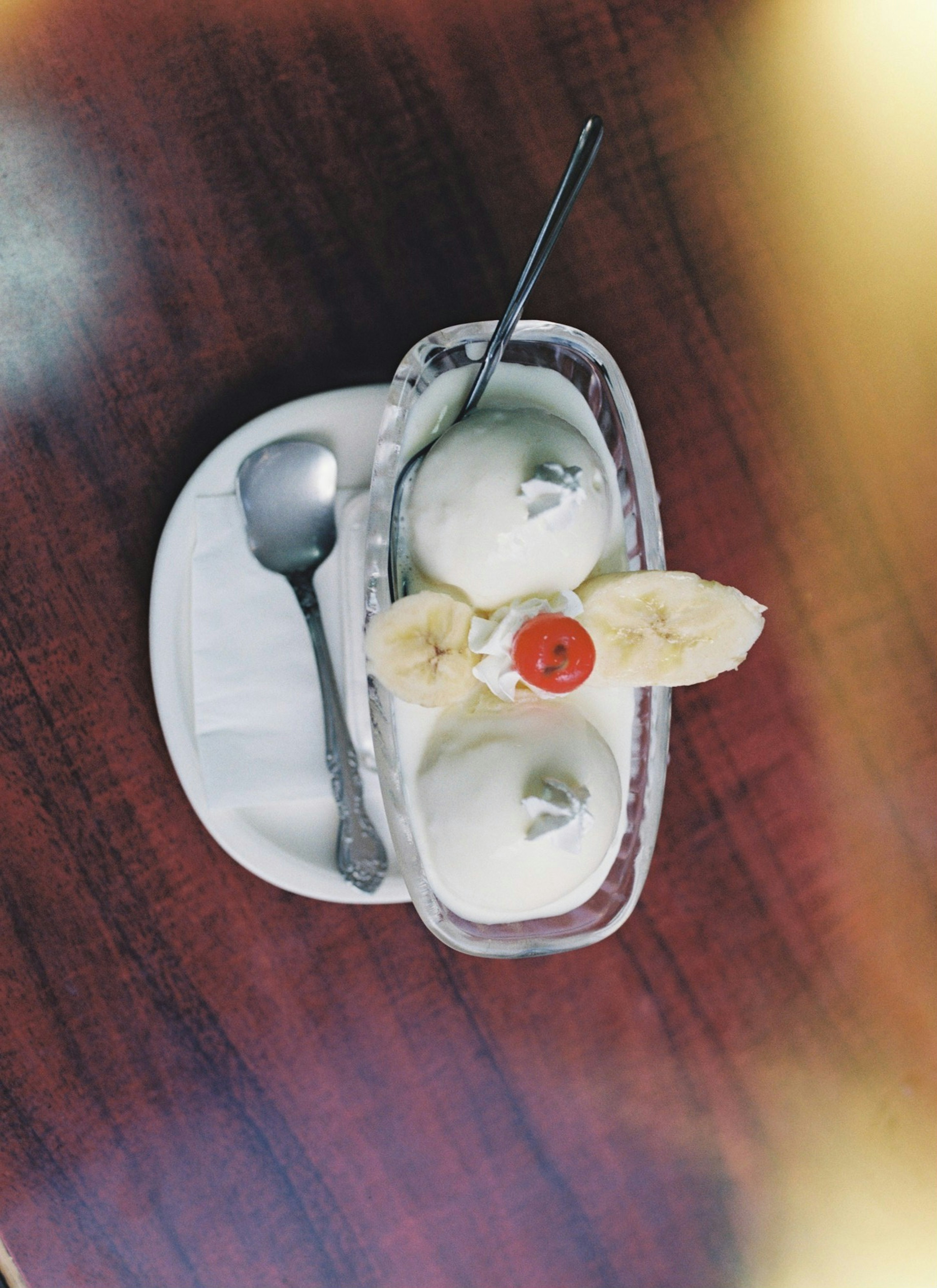 Dessert avec de la glace garnie de banane et de cerise