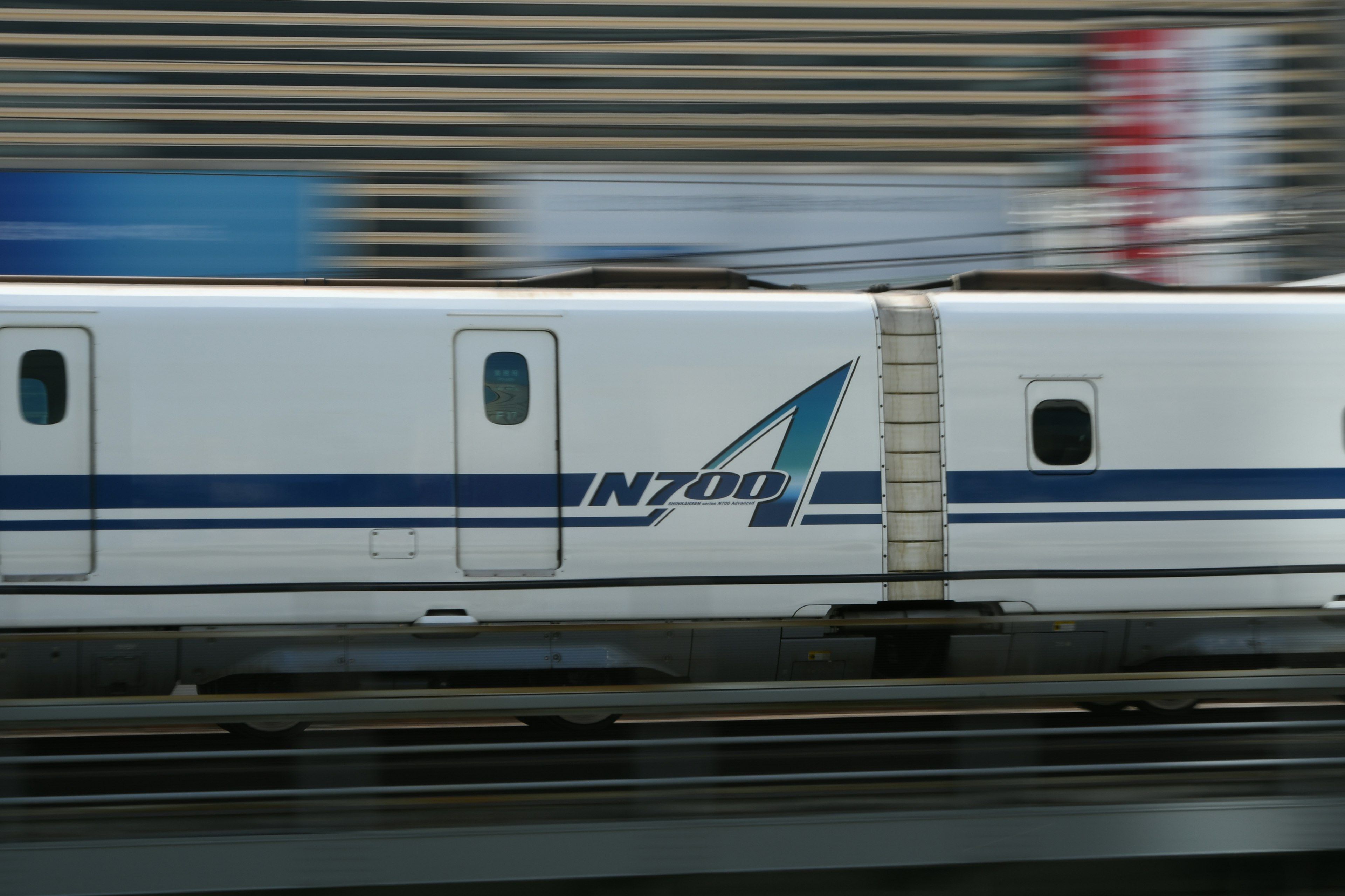 Imagen de un tren Shinkansen moviéndose rápidamente con efecto borroso