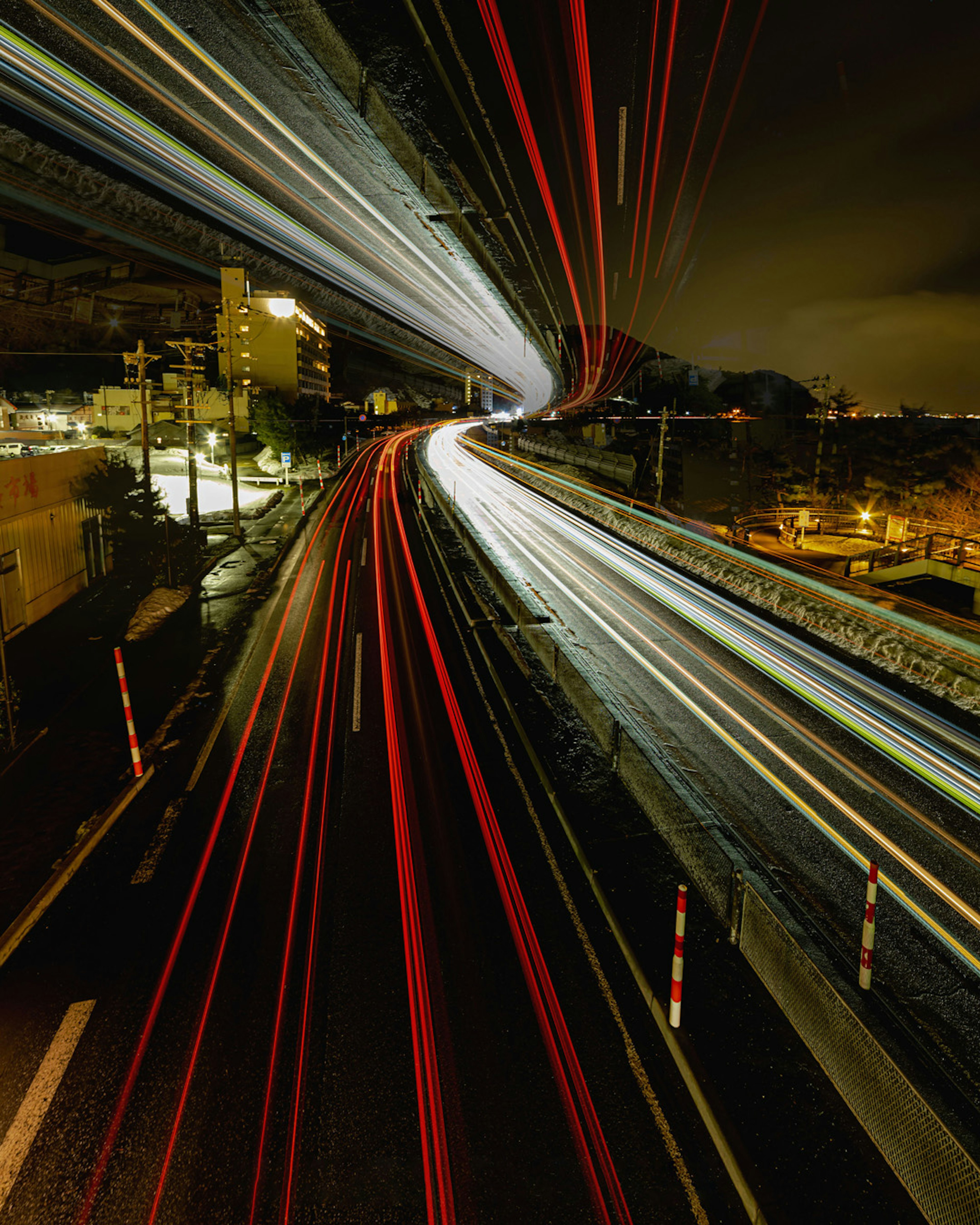 Image of light trails from cars on a city road at night