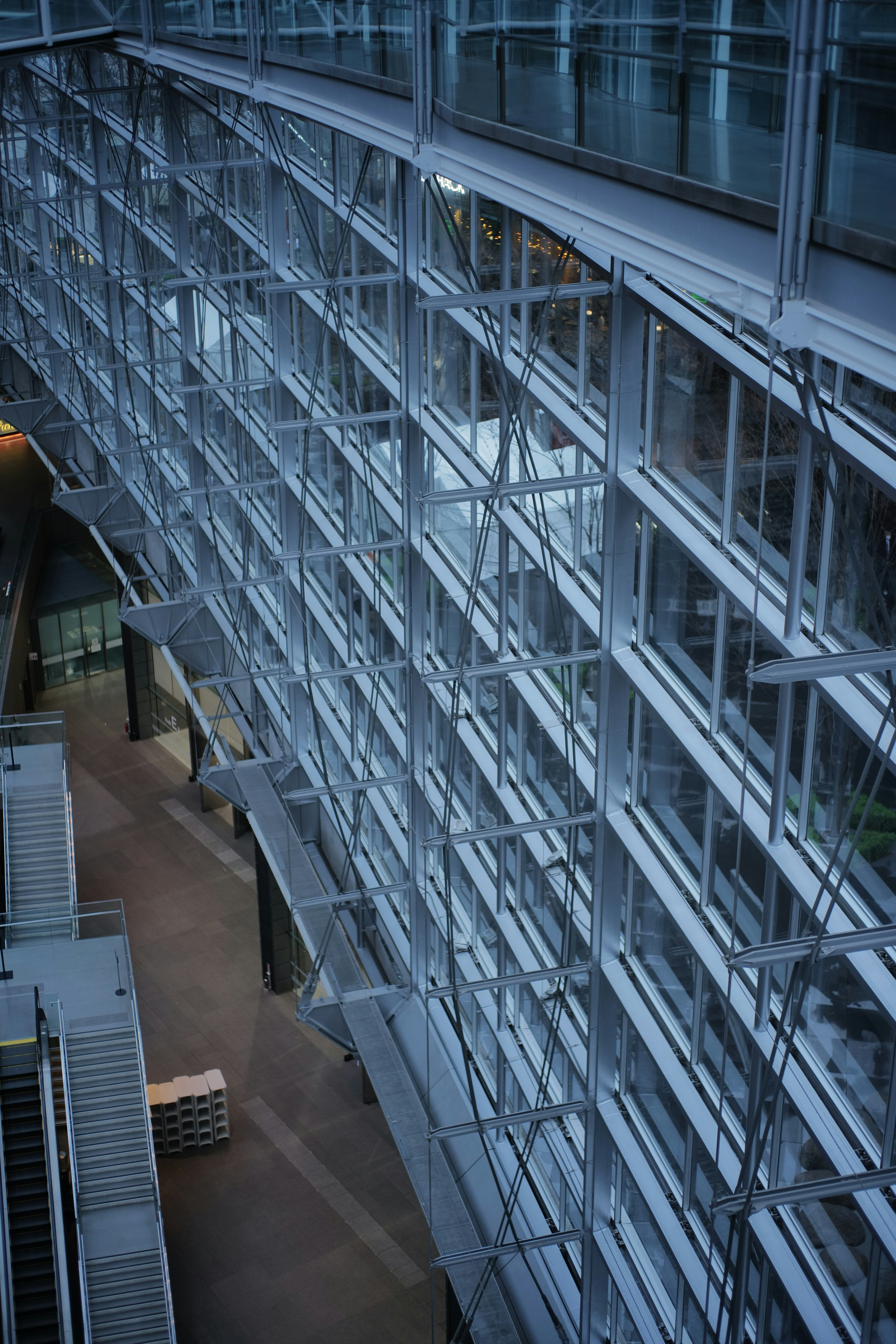 Façade moderne d'un bâtiment en verre et en métal avec un design linéaire et des couleurs vives