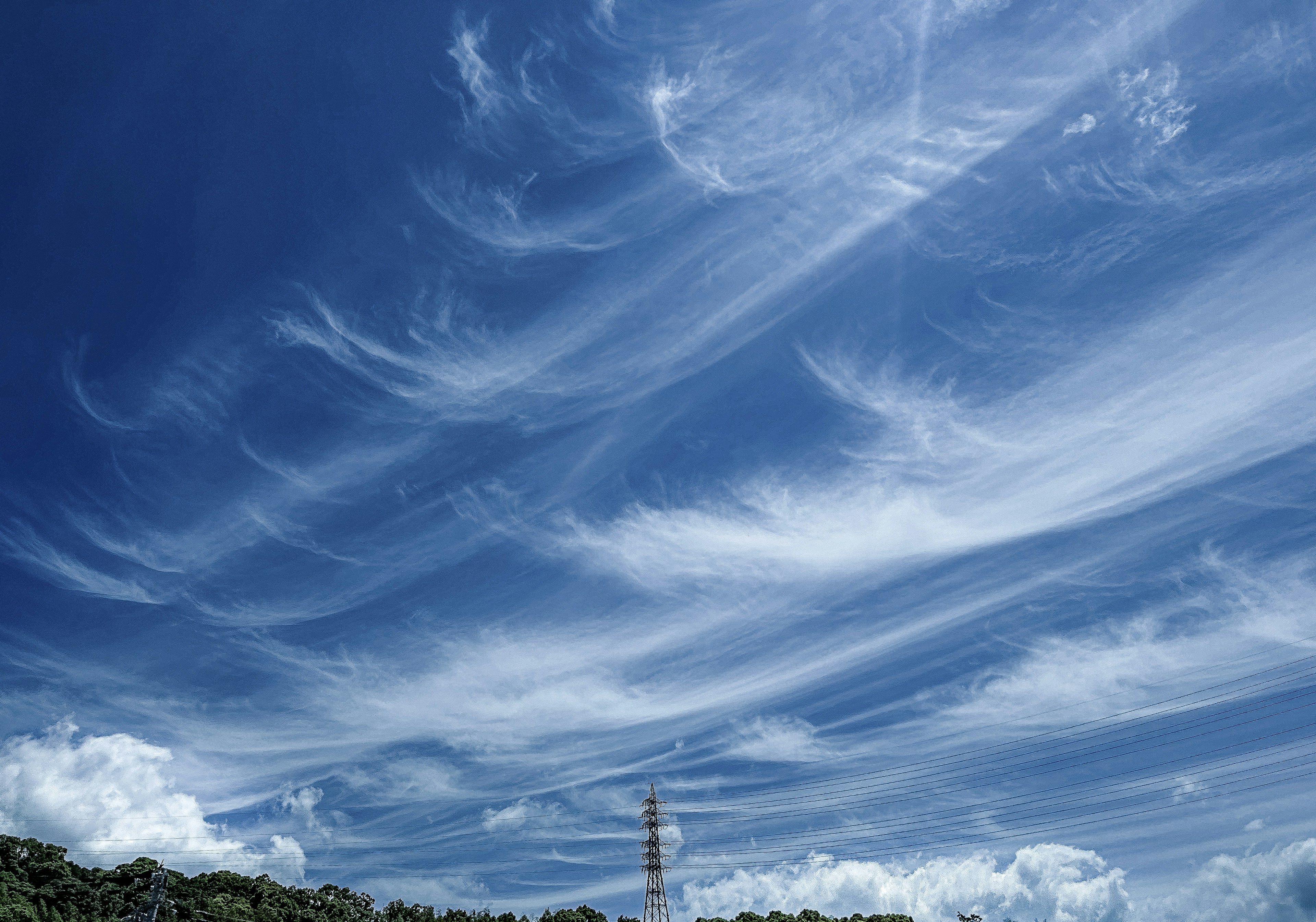 青空に広がる流れる雲と山の風景