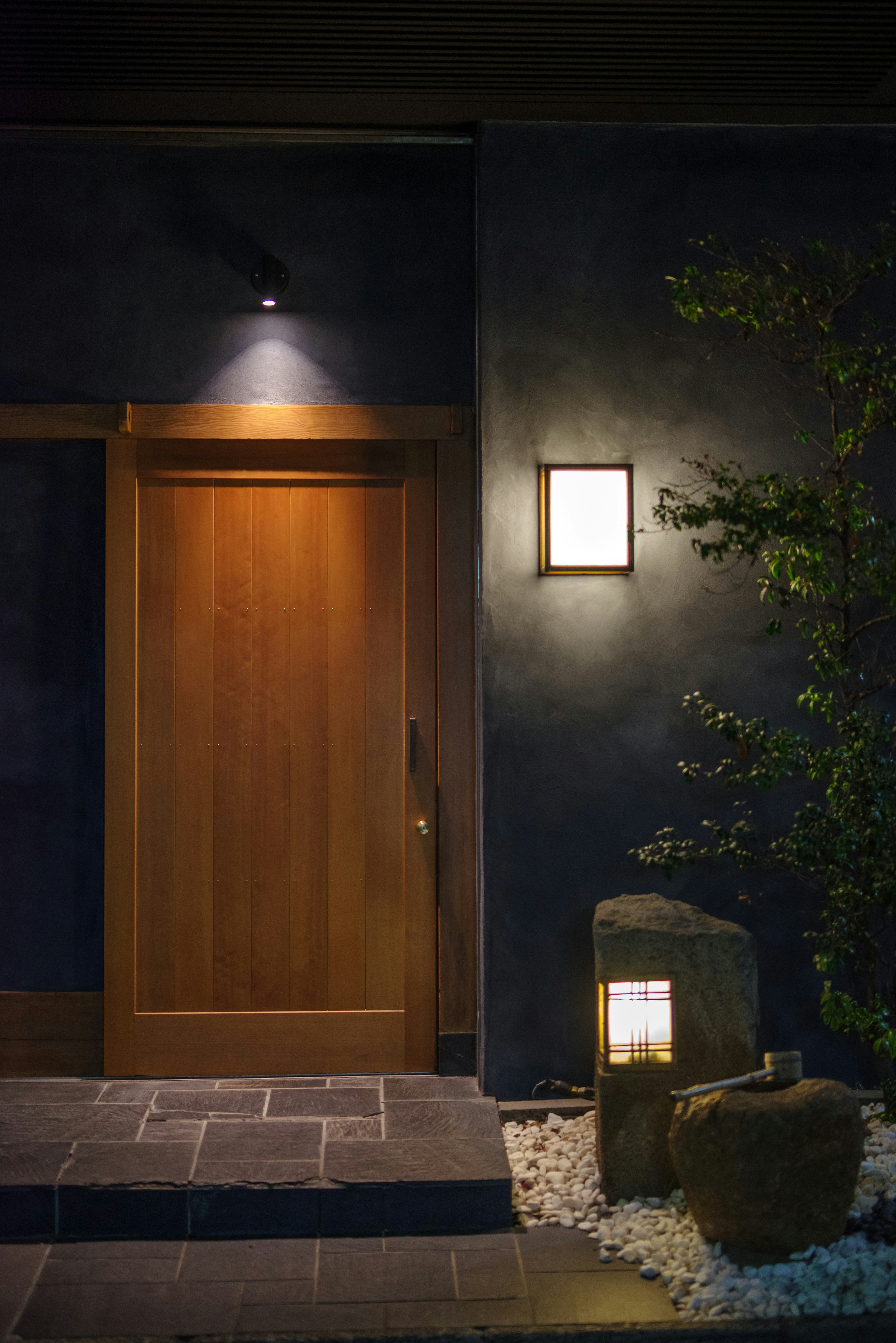 Modern entrance with wooden door and ambient lighting