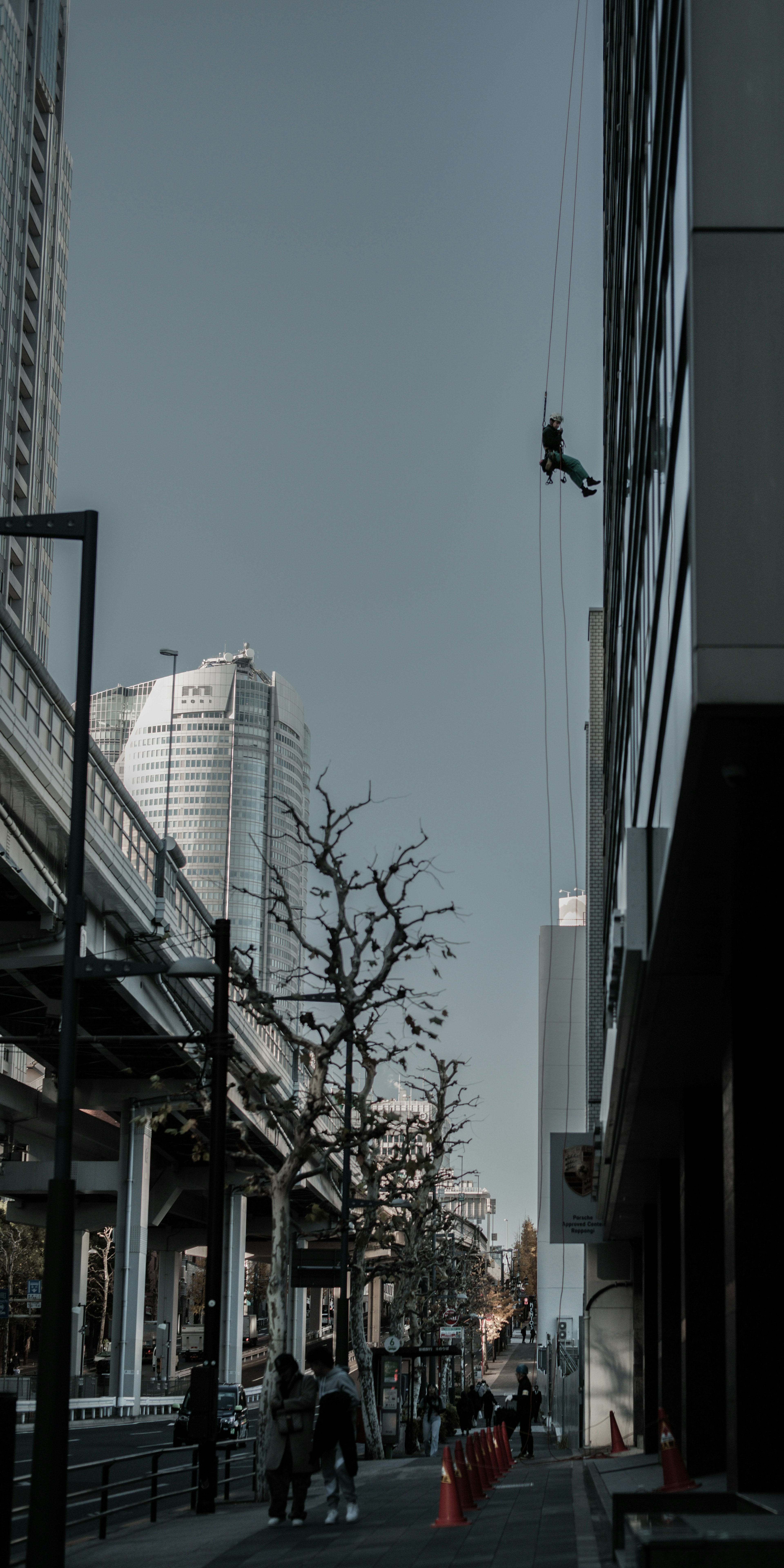 Worker rappelling down a skyscraper with urban scenery