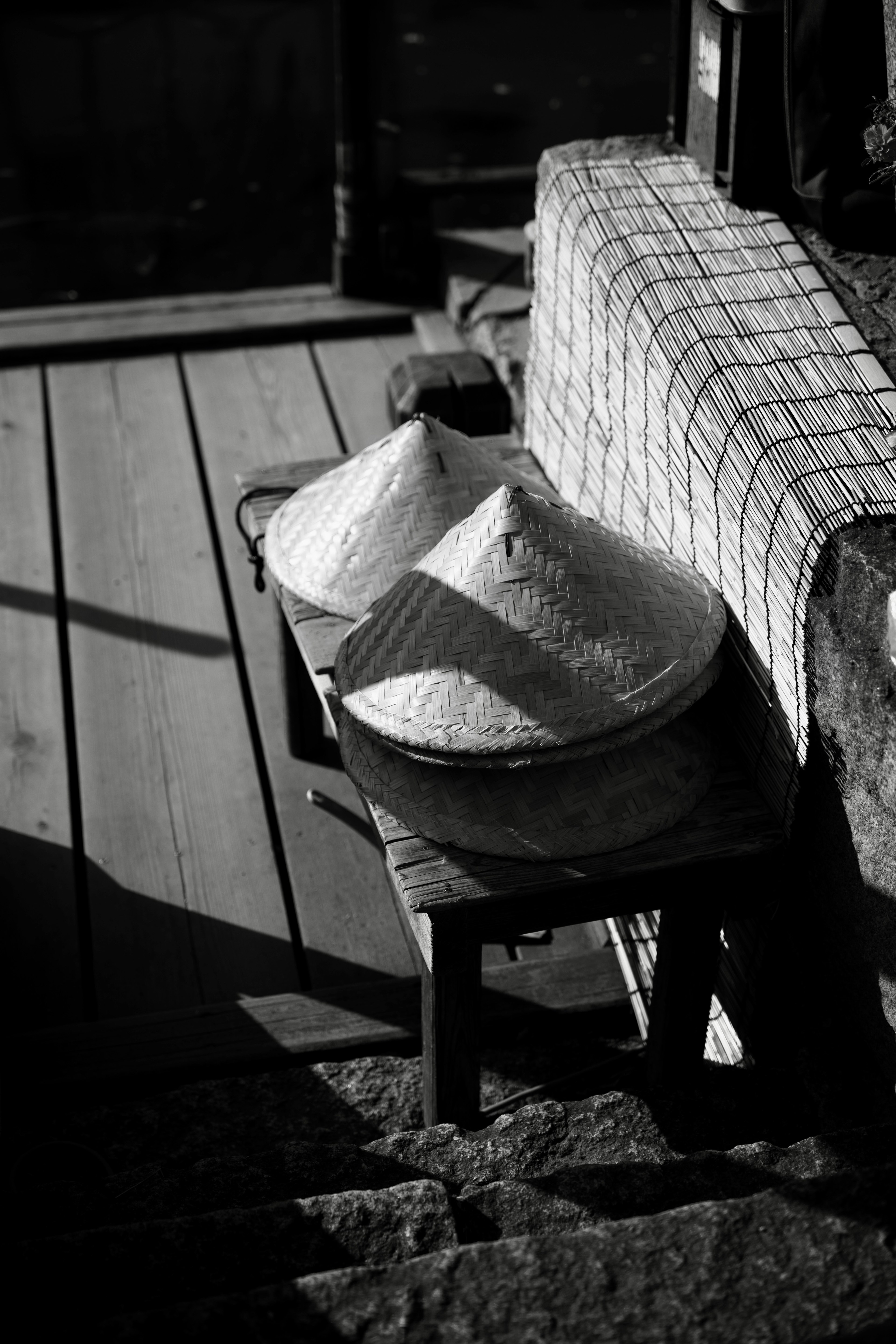 Zwei asiatische Hüte auf einem Holztisch mit einem karierten Tuch