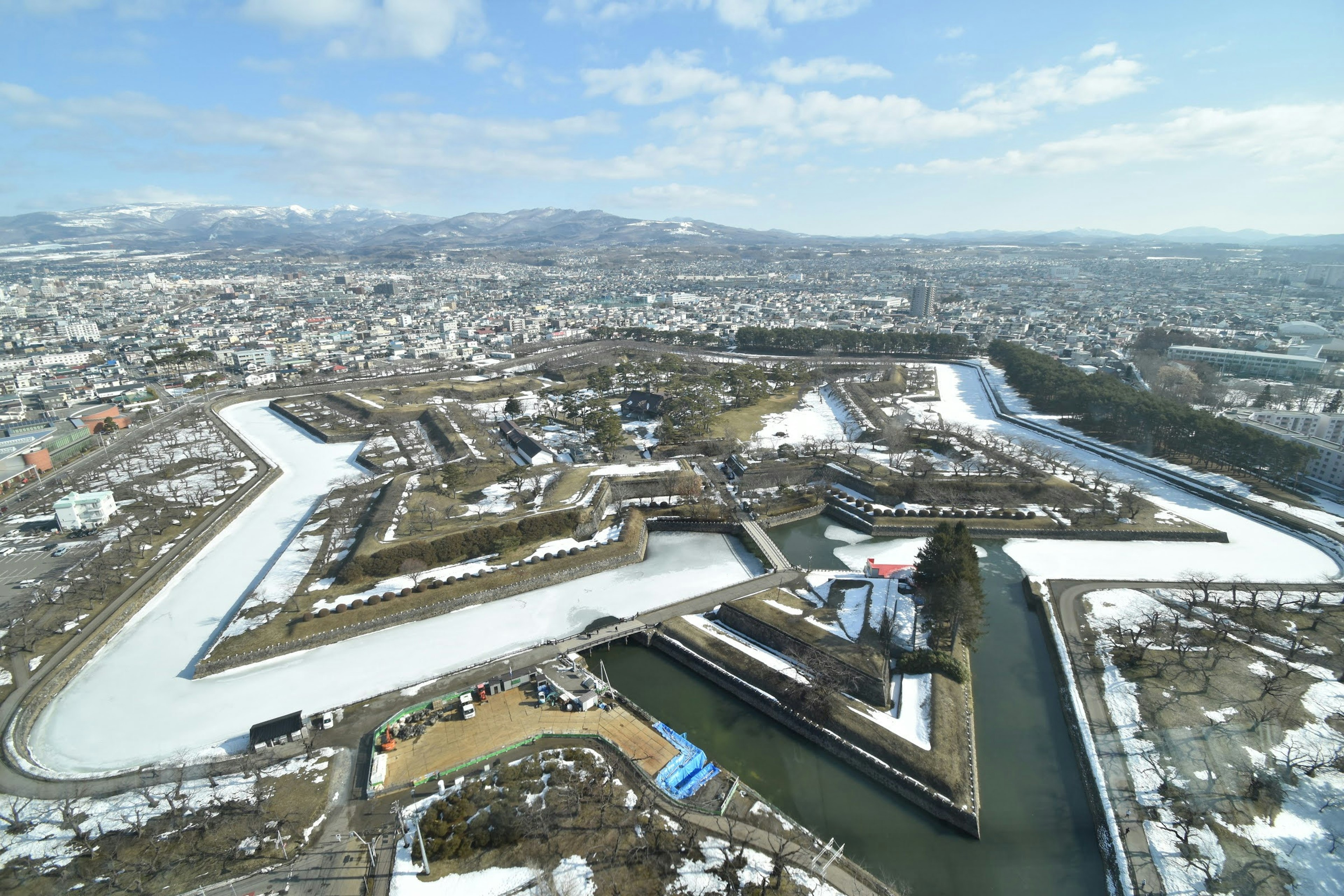 Aerial view of a snowy landscape with winding rivers and urban areas