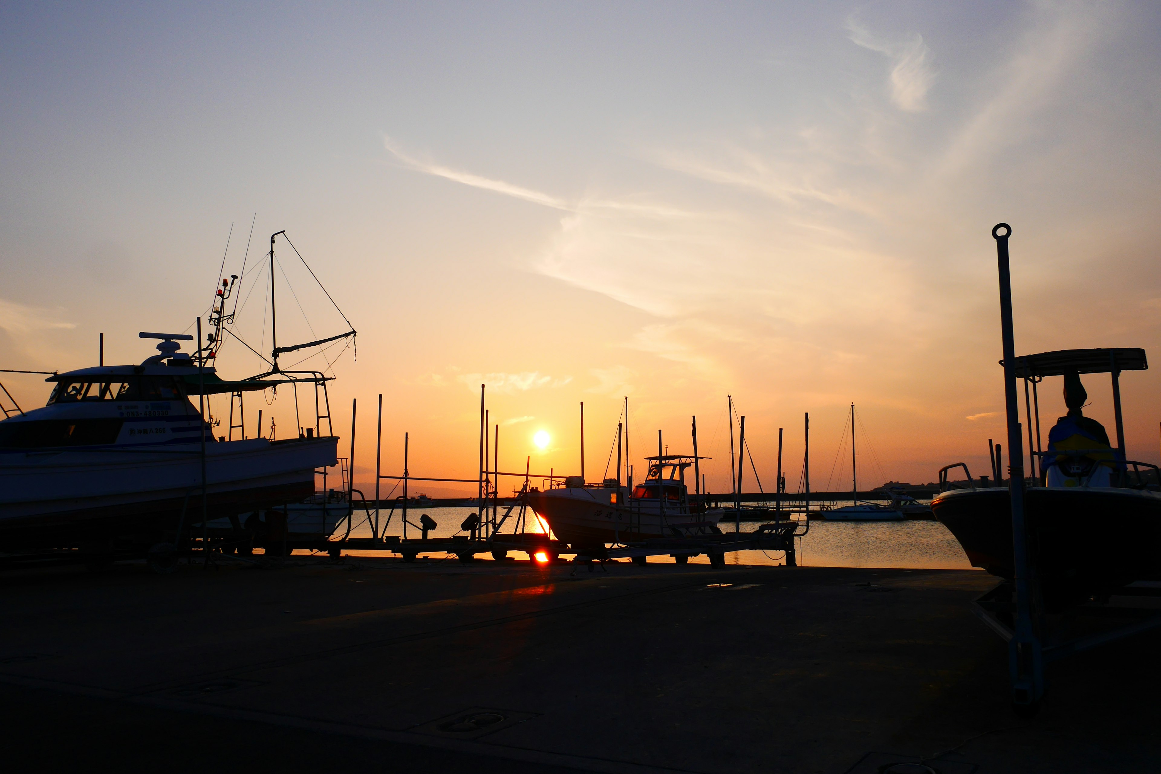 Silhouette von Booten in einem Hafen bei Sonnenuntergang