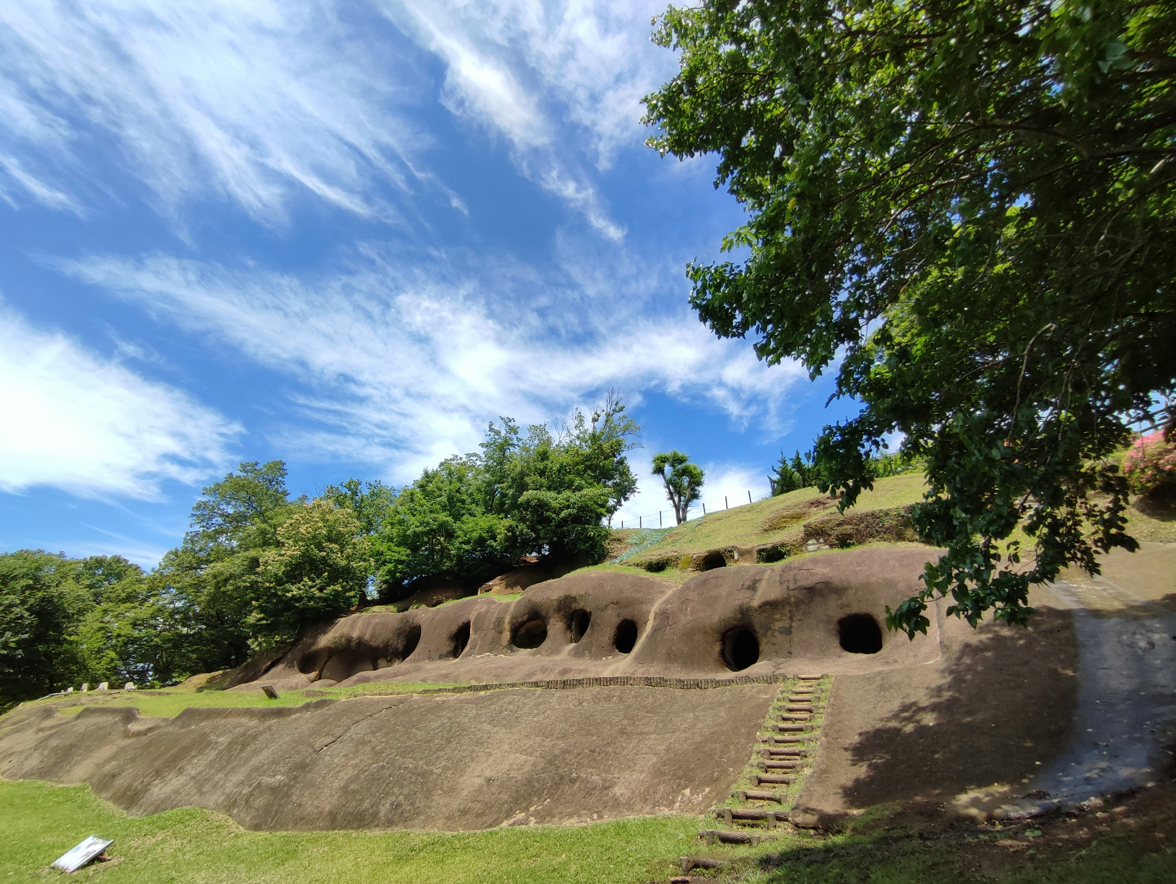 大きな土の構造物と緑の木々がある風景 青空が広がる