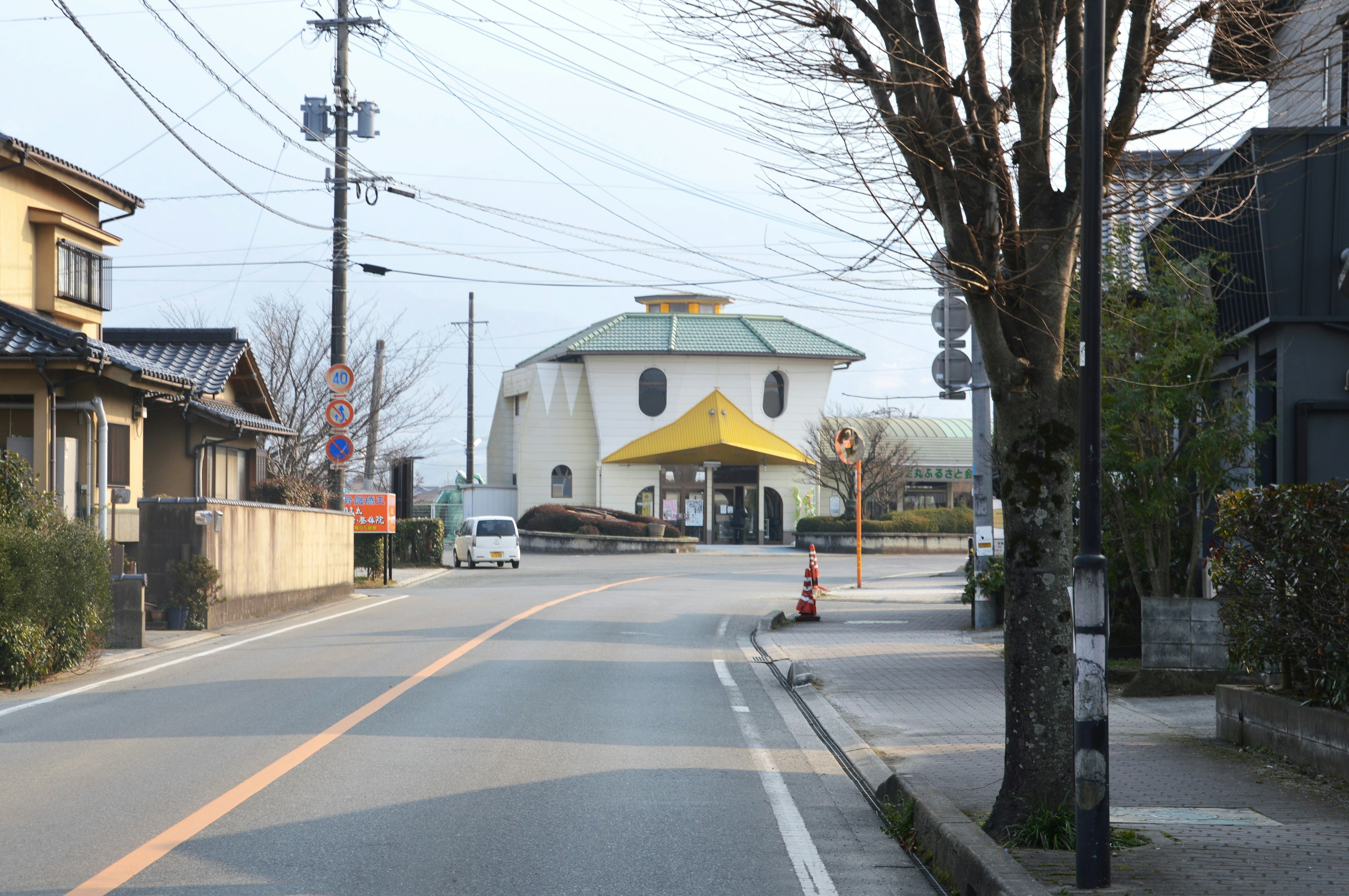 Una escena de calle tranquila con un edificio único de techo amarillo a lo lejos