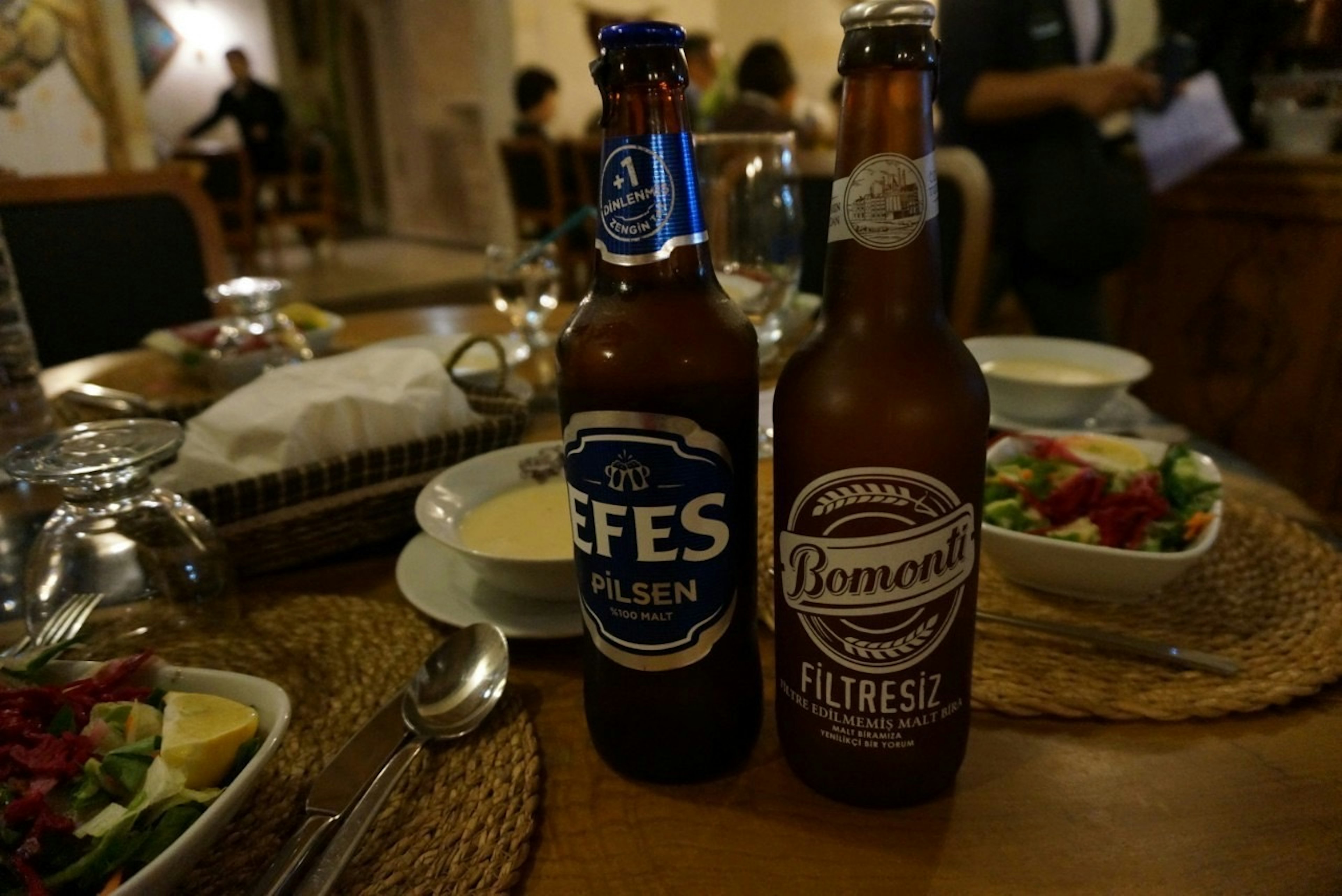 Deux bouteilles de bière Efes et Bomonti sur une table de dîner